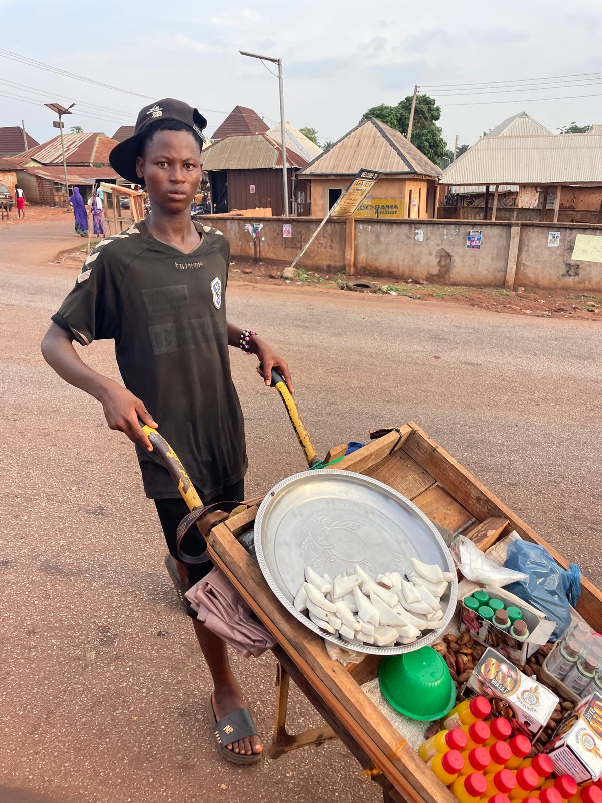 Man in black clothing stands on red road in Apunu