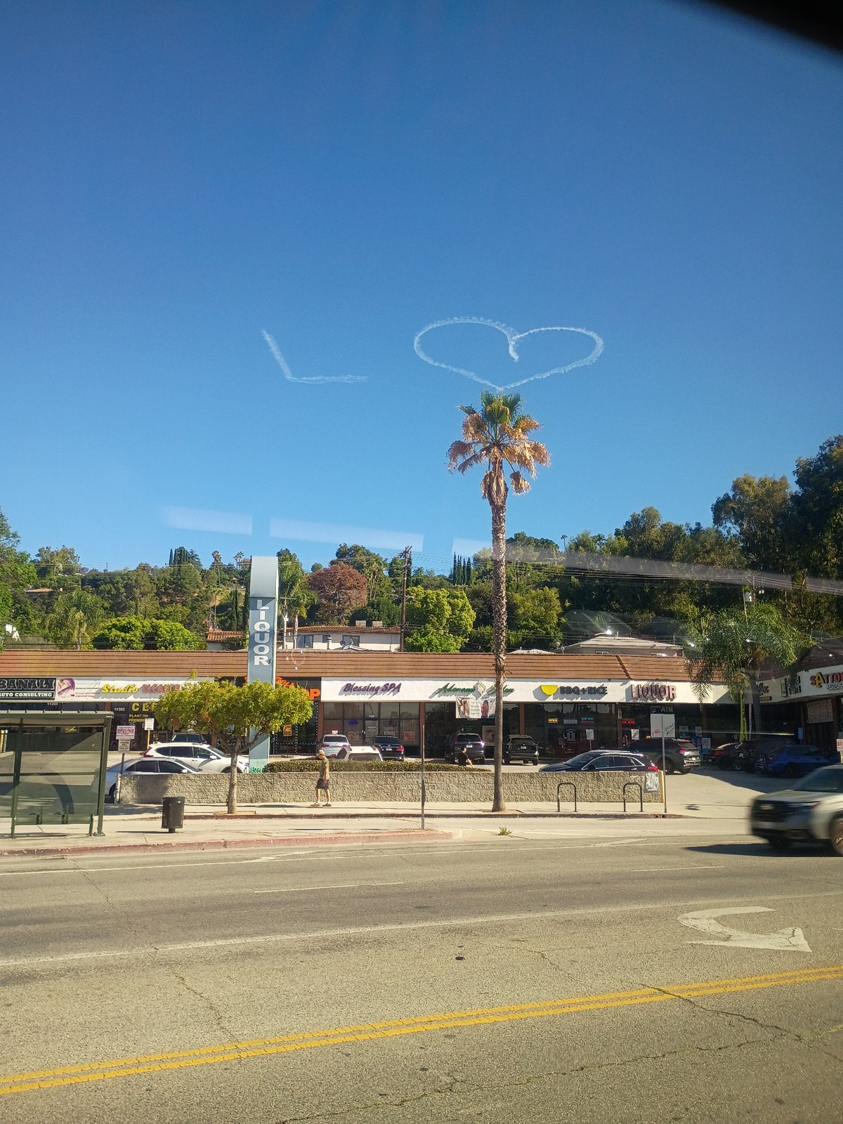 Skywriting contrails form a heart above Los Angeles streets
