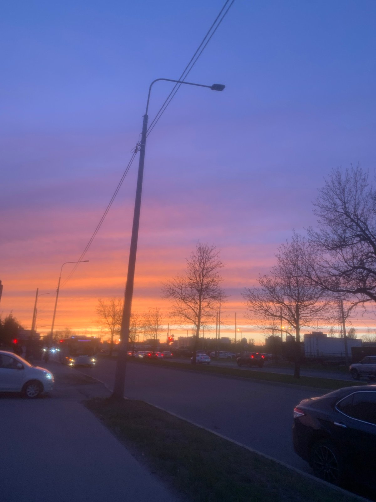 Woman rides scooter during colorful sunset at dusk