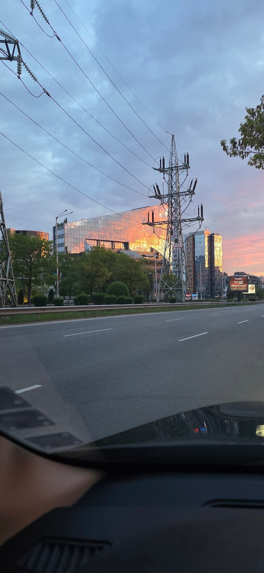Early morning drive captures mirrored building reflecting sunset in Sofia
