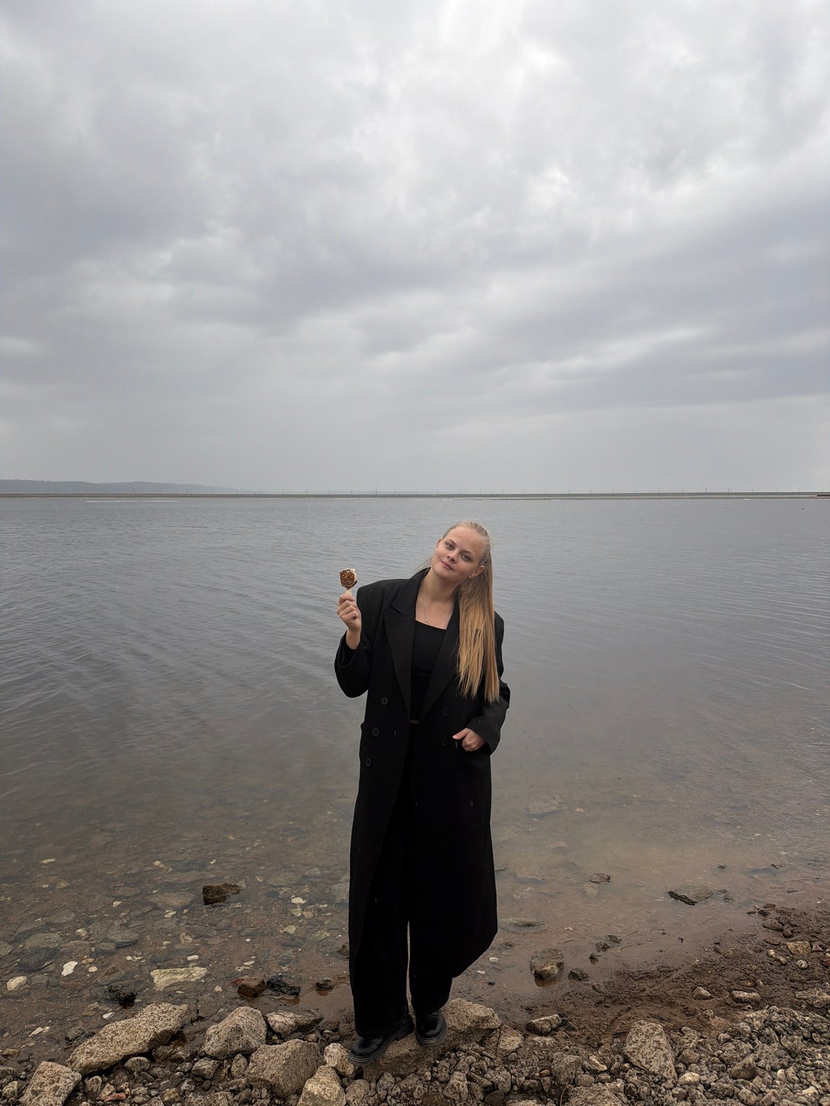 Woman enjoys ice cream by waterfront in Chaikovsky