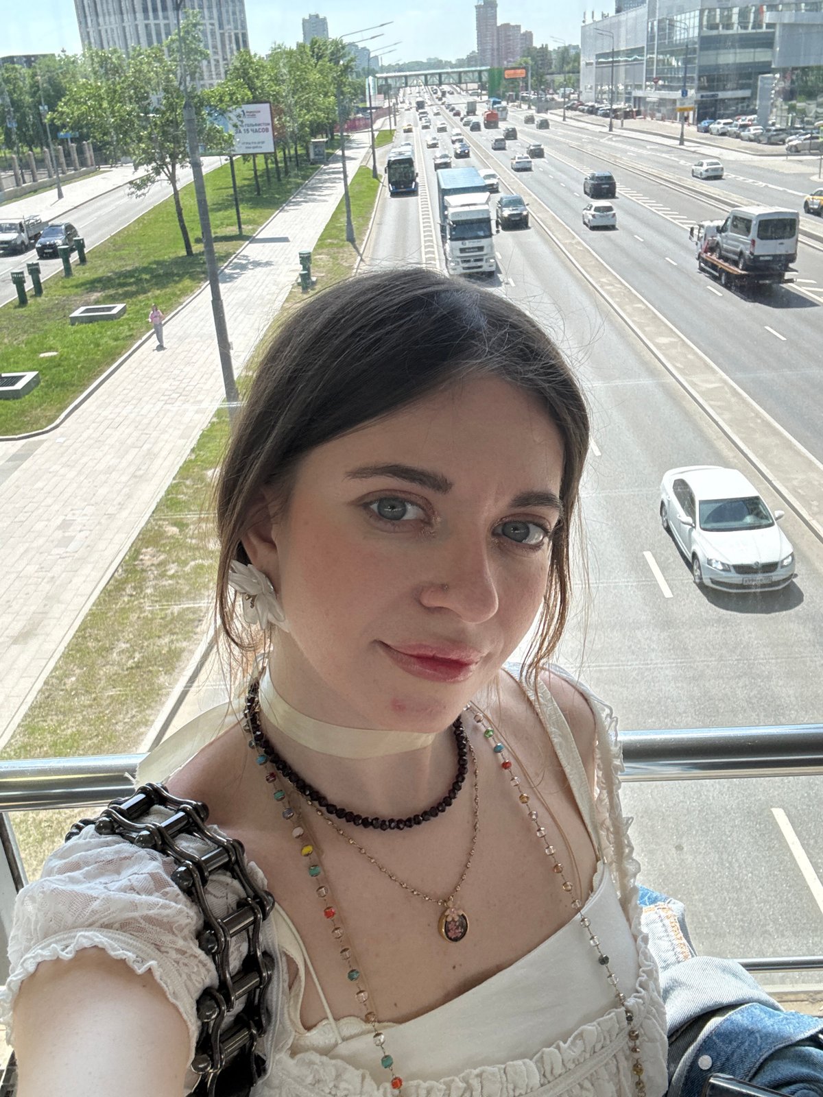 Woman documents Moscow cityscape from pedestrian bridge