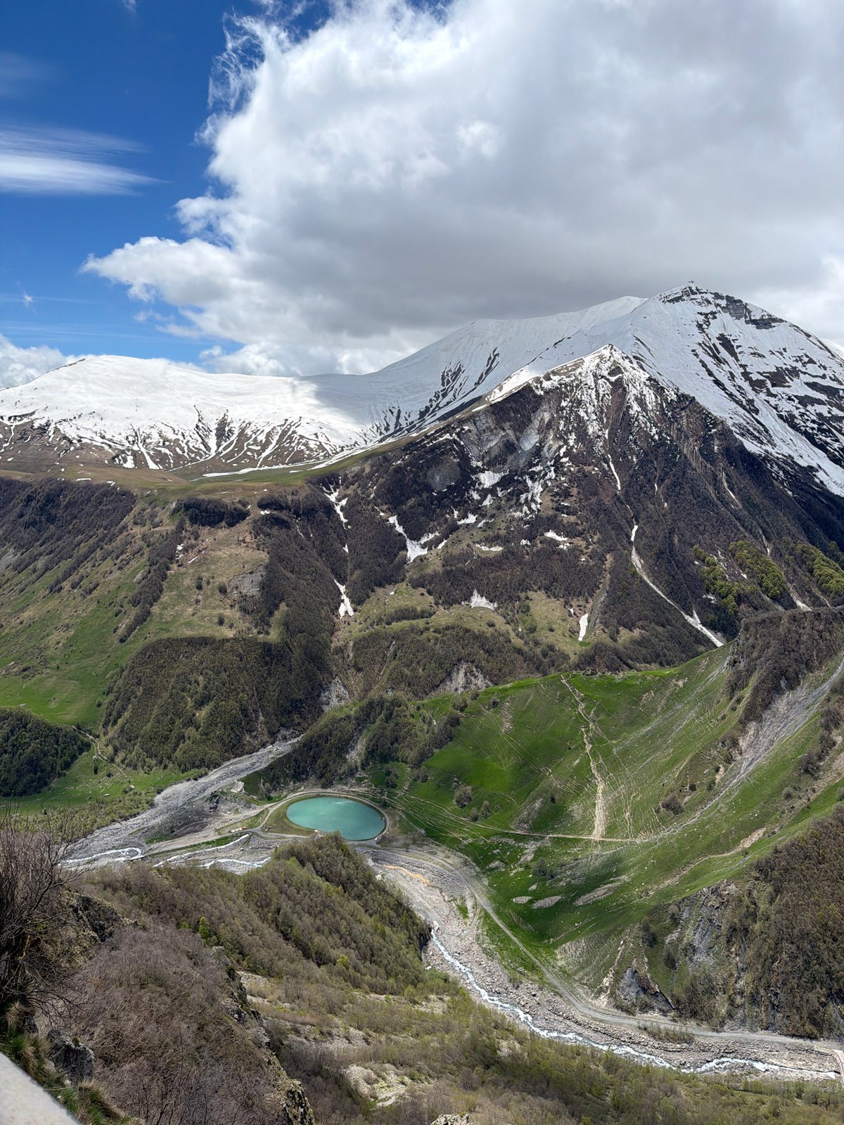 Tourist documents friendship monument and snowy peaks in Gudauri