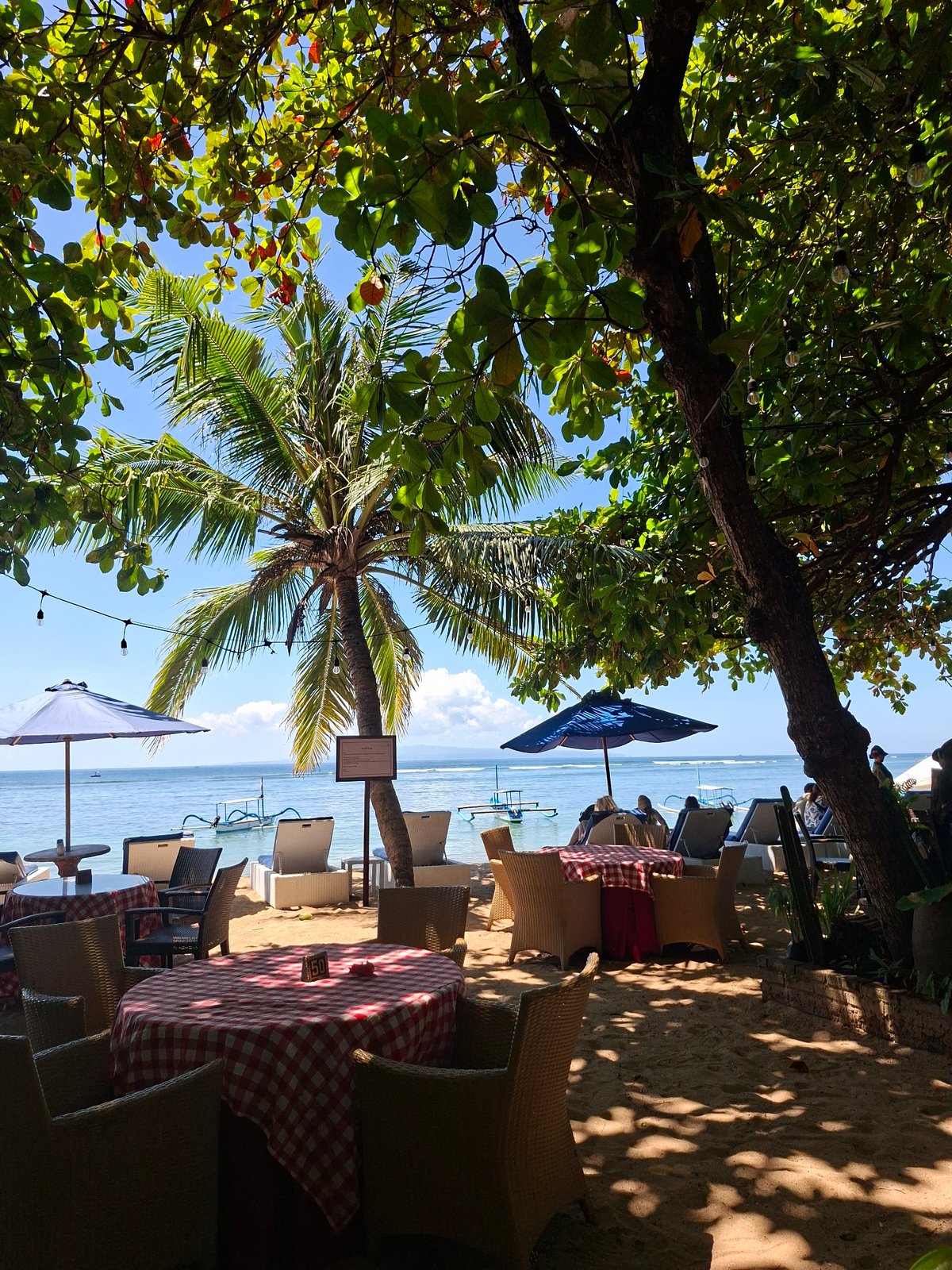 Beachside dining scenes with Buddha sculptures documented in Denpasar
