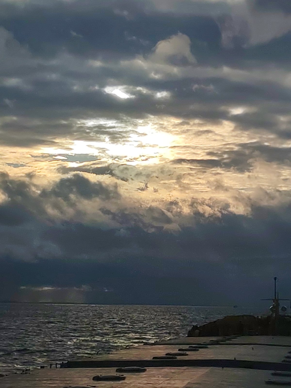 Cloudy afternoon captured at concrete pier with choppy waters