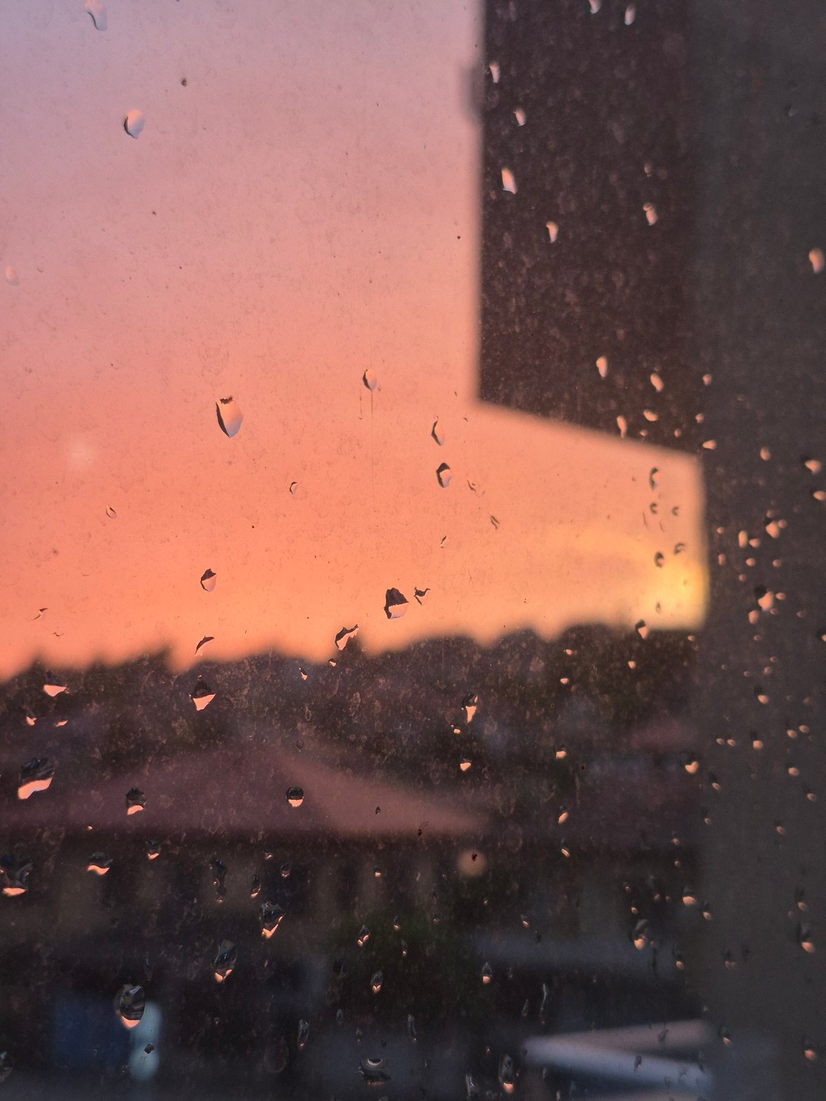 Rain-streaked window frames a sunset over Popovo, Bulgaria