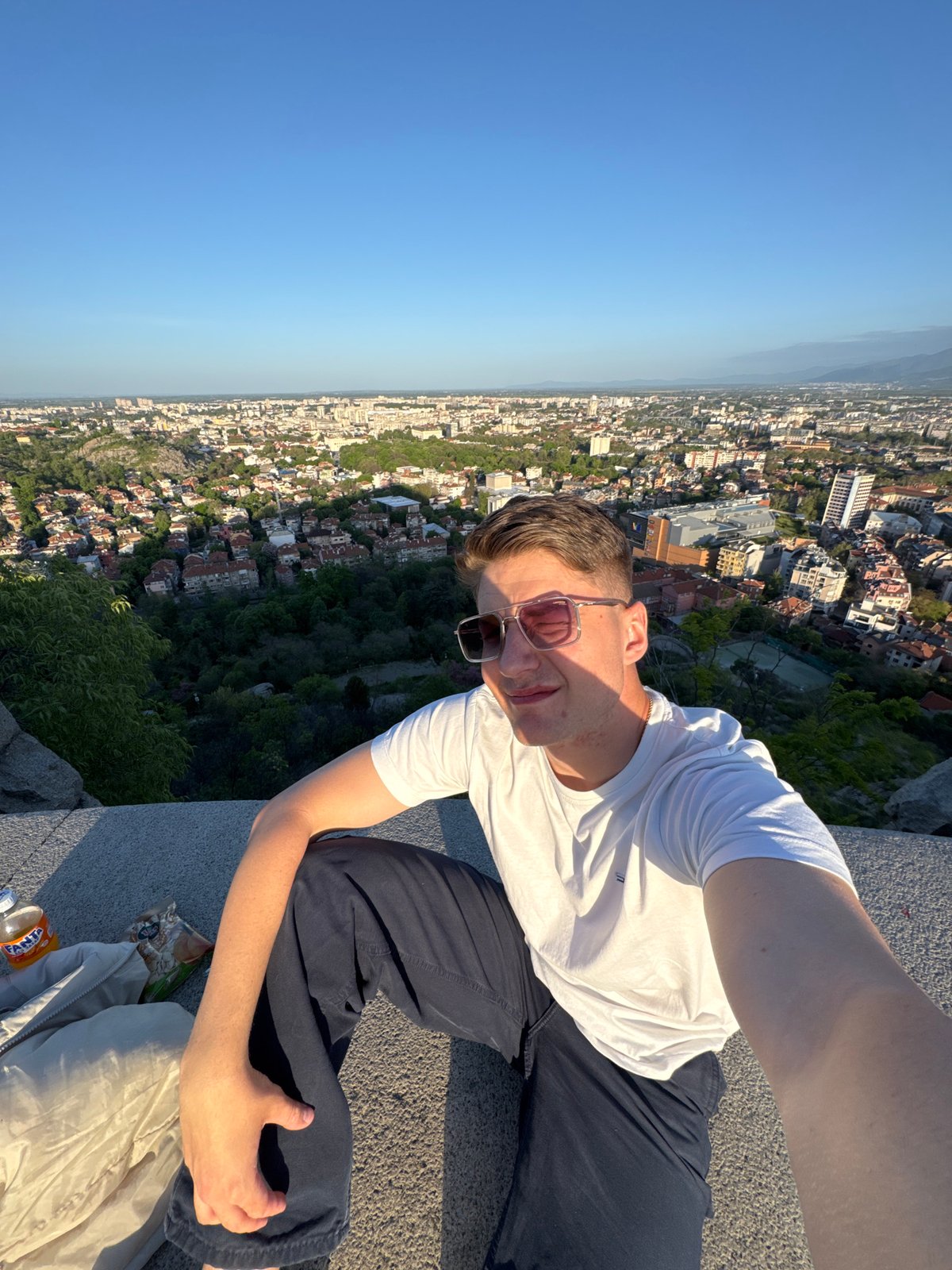 Young man photographed on stone ledge overlooking Plovdiv