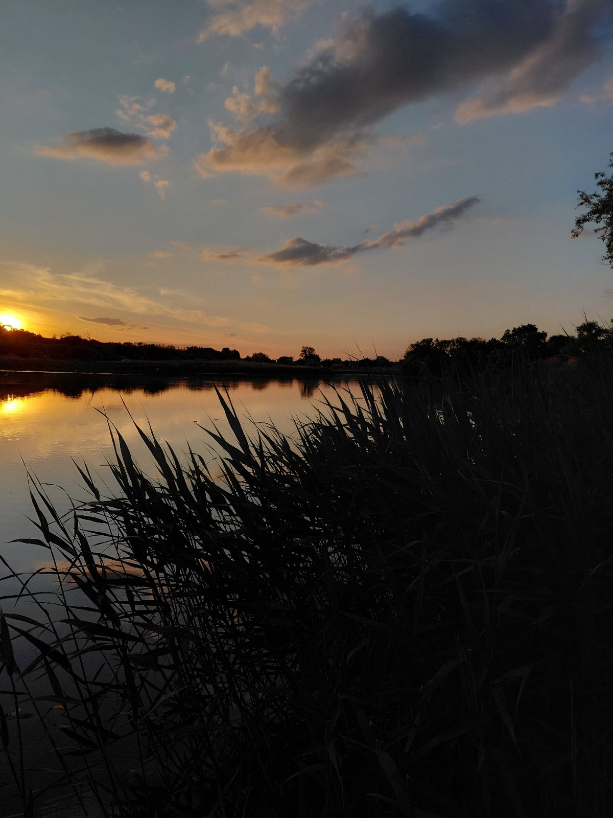 Sunset documented over Ustyvytsia waters in rural Ukraine