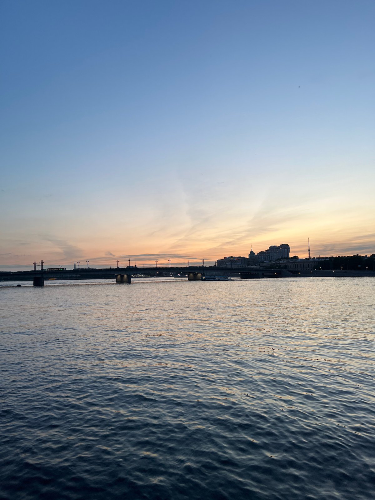 Twilight cityscape captured showing river, bridge, and gradient sky