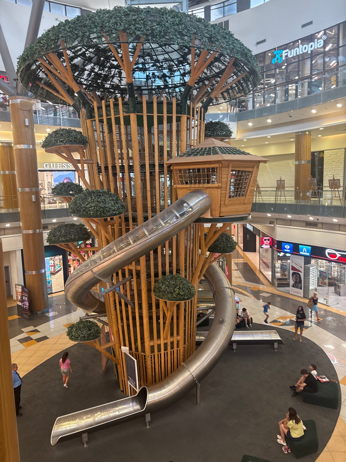 Multi-level treehouse playground dominates a shopping mall atrium