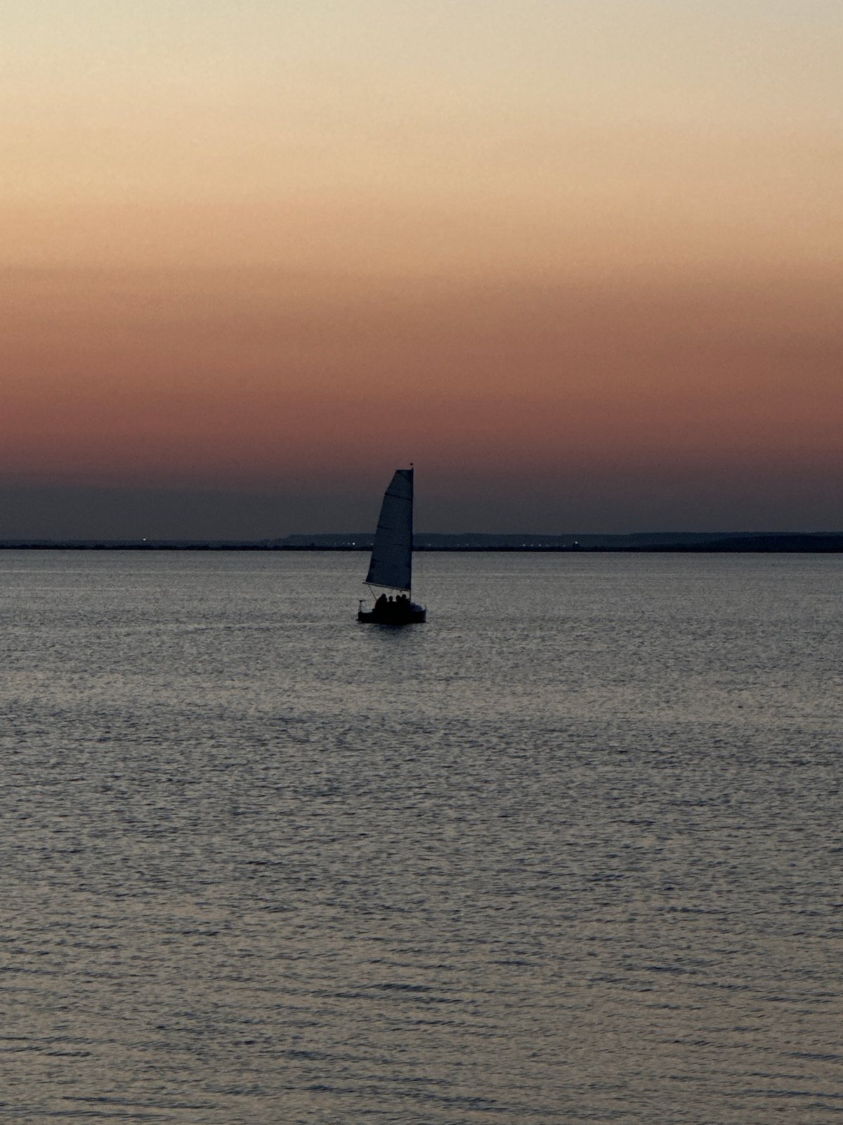 Sailboats and paddleboards on a Kokshetau lake at sunset