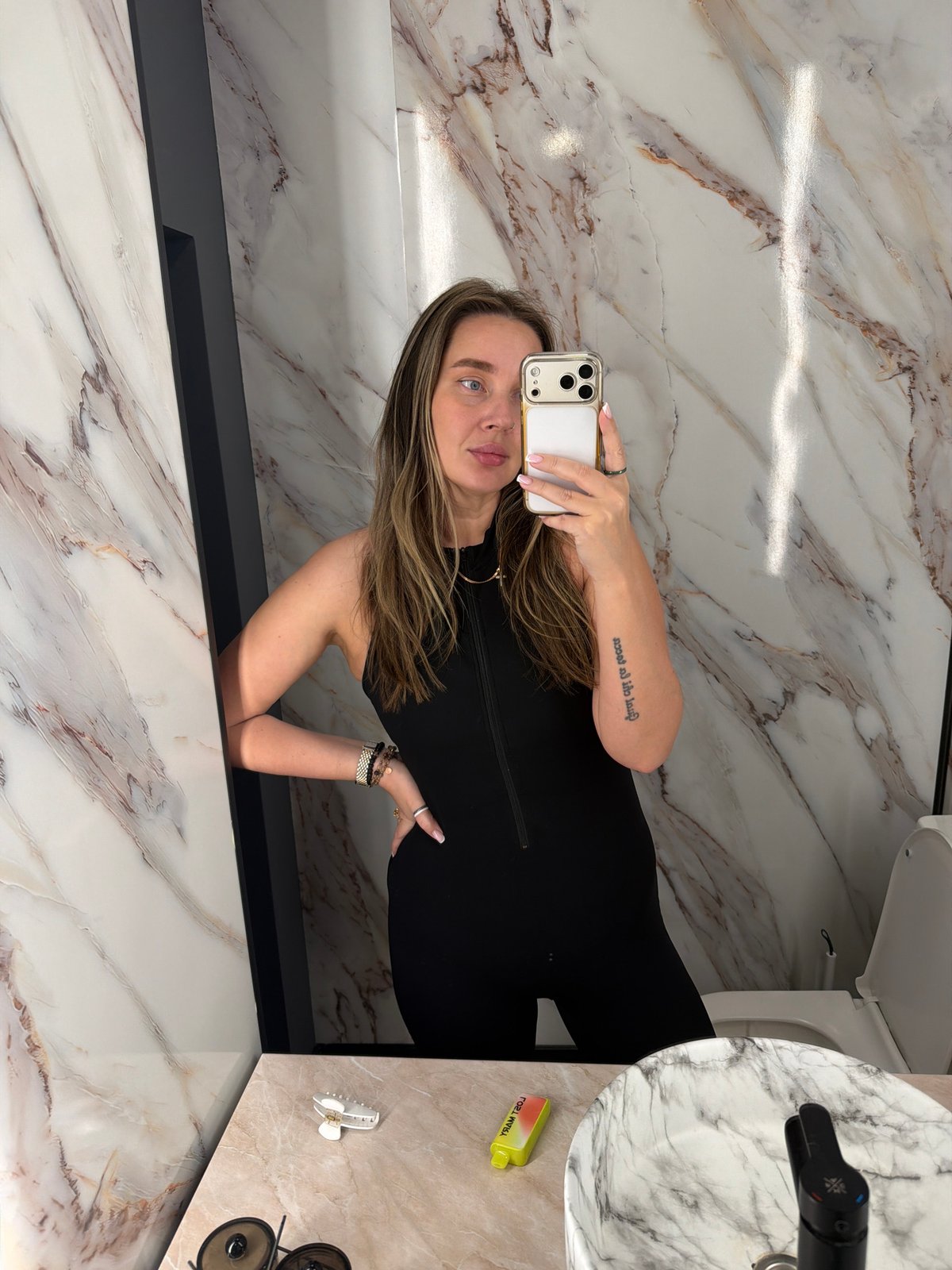 Woman takes bathroom mirror selfies in Moscow marble restroom
