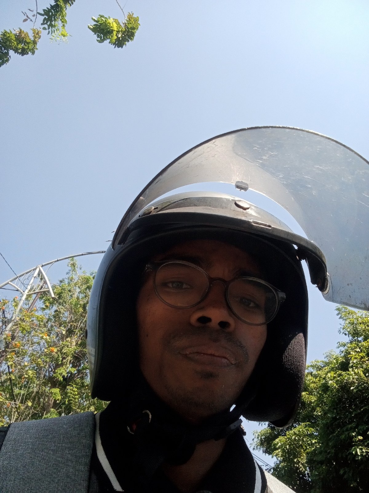 Helmeted rider at a Surabaya railway crossing