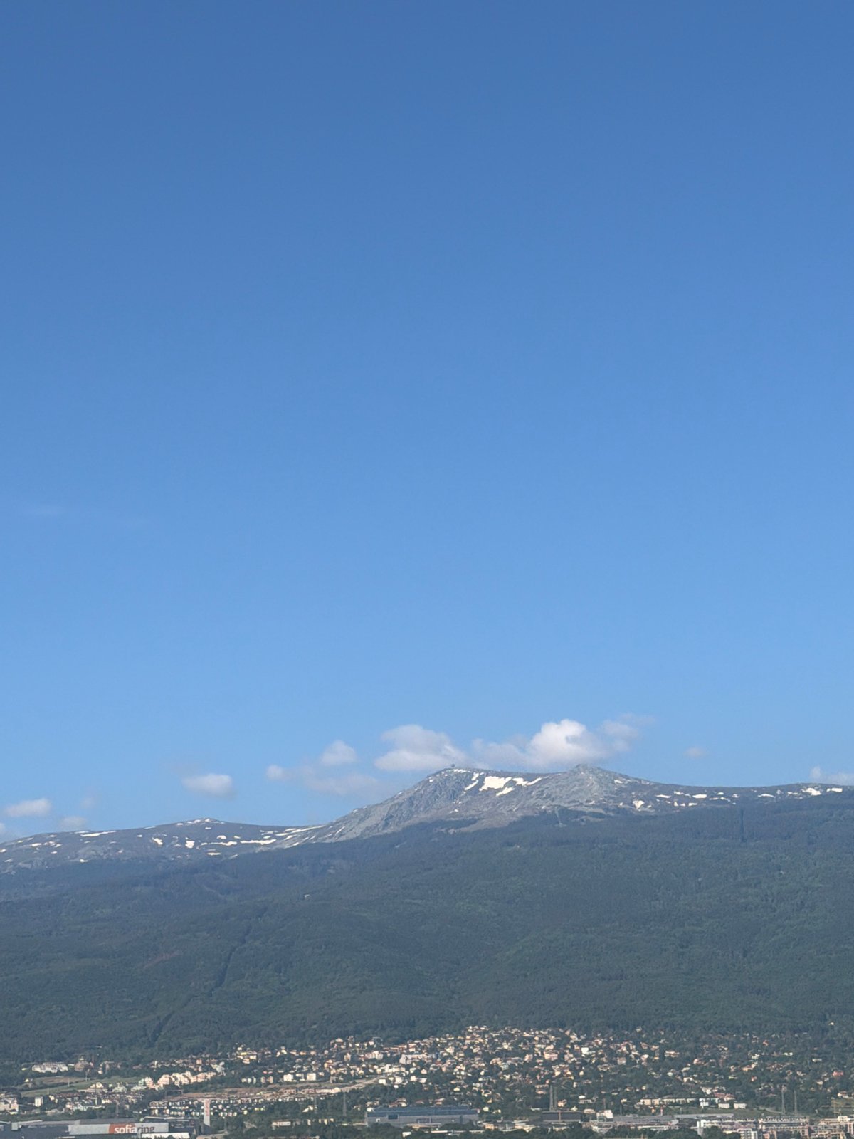 Morning view captures Sofia cityscape against snowy mountain backdrop