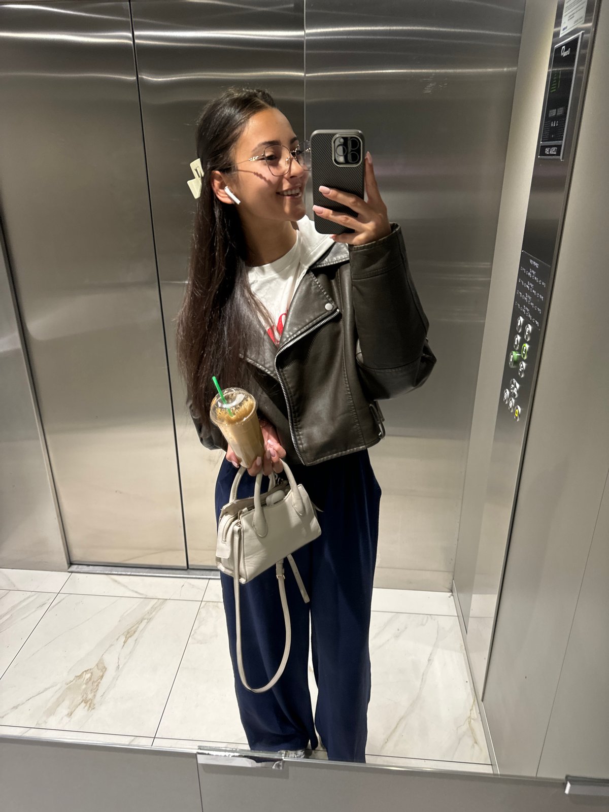 Woman takes selfie in marble-floored elevator in Sofia