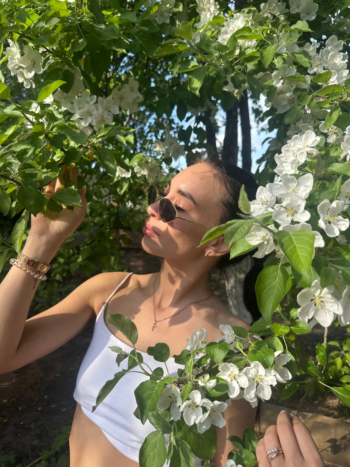 Woman poses among apple blossoms in Chaikovsky, Russia