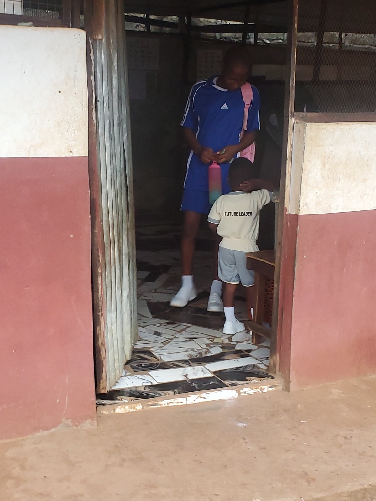 Children photographed in school uniforms around Ukwu-Abwa buildings