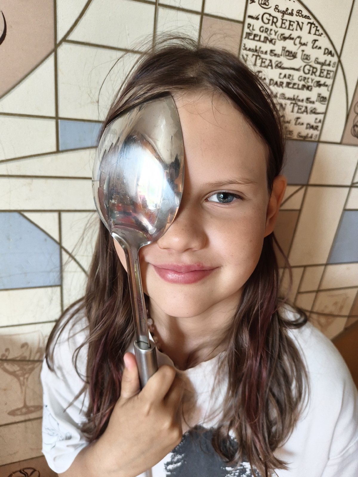 Playful eye-covering with spoon and grey tabby cat portraits