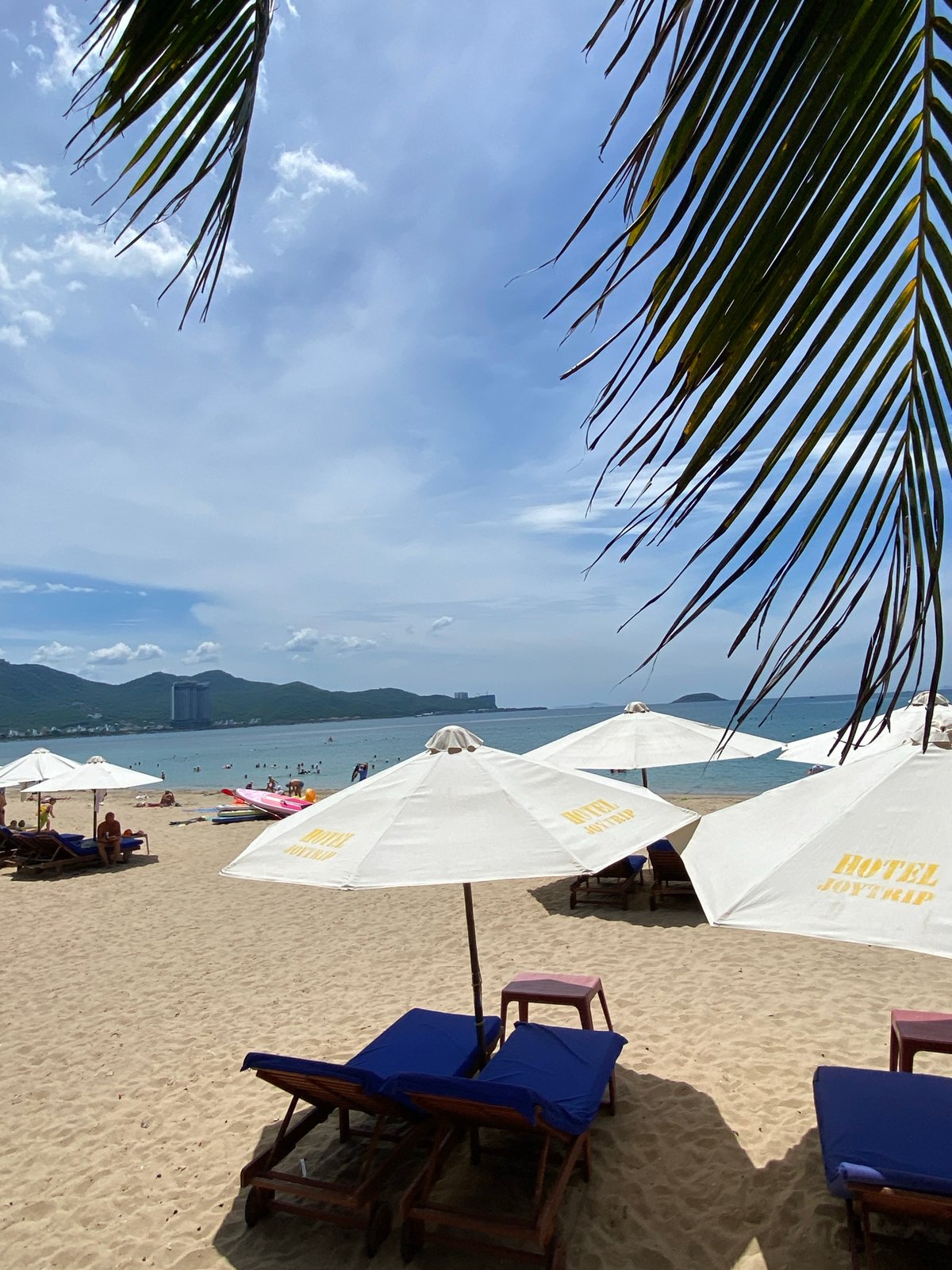 Nha Trang beachfront at dawn, vendors and locals along the shore
