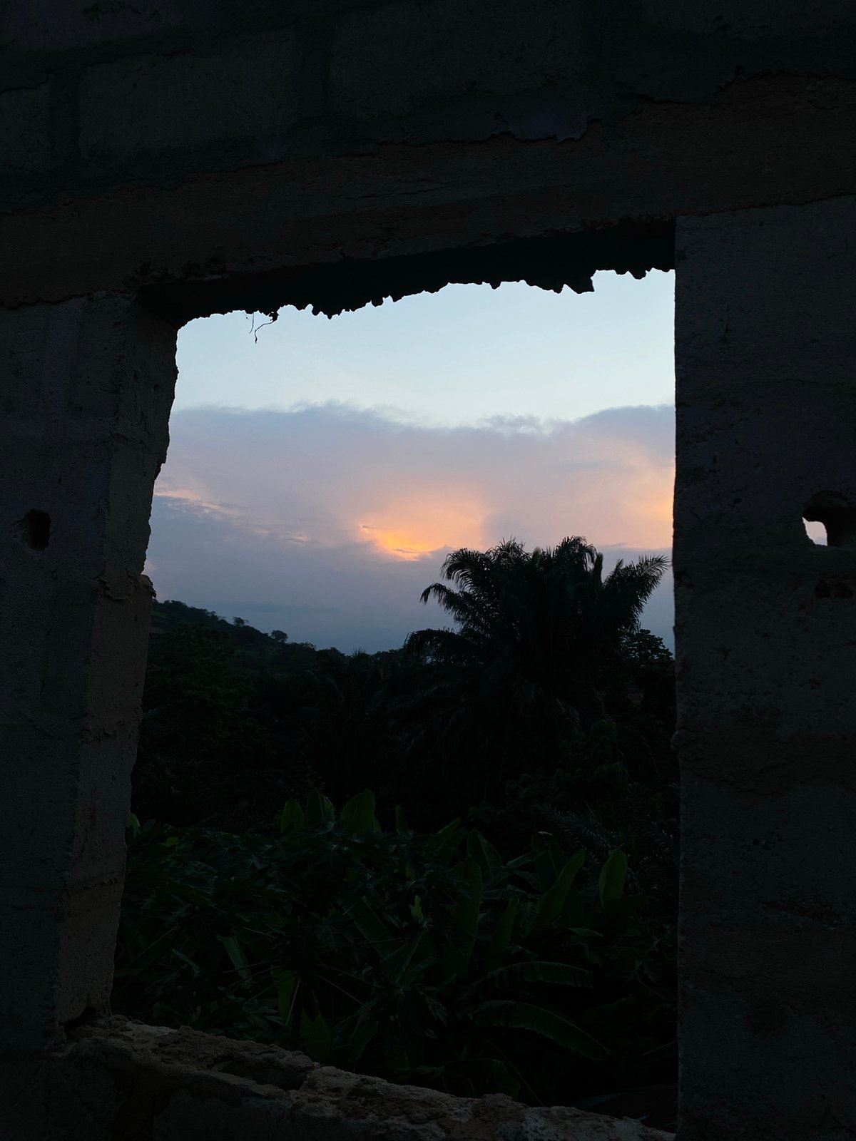 Evening sky viewed through unfinished building in Achara, Nigeria