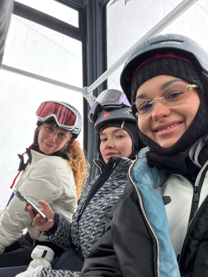 Skiers ride lifts during overcast day in French Alps