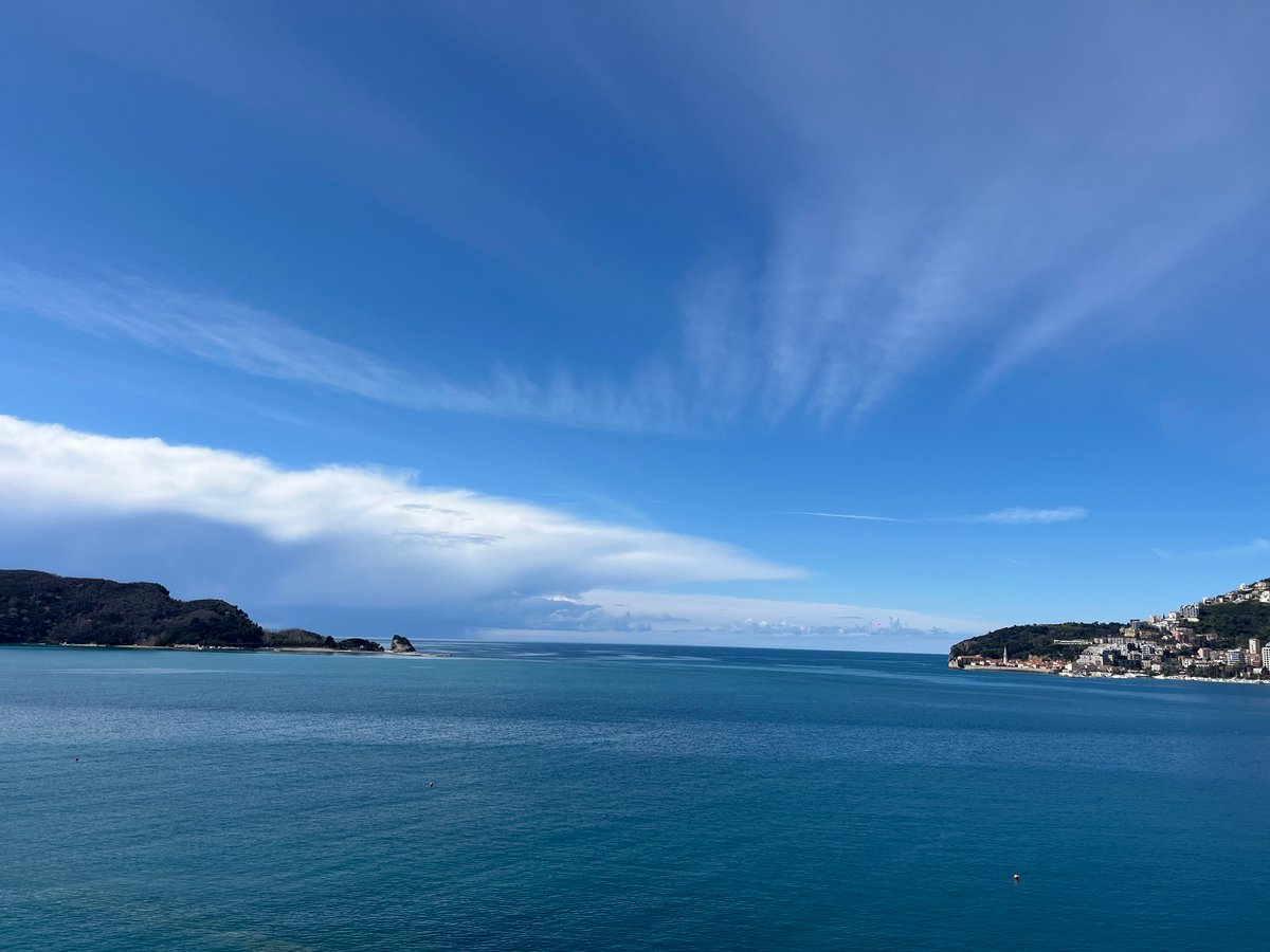 Tourist photographs Budva coastline from clifftop overlooks