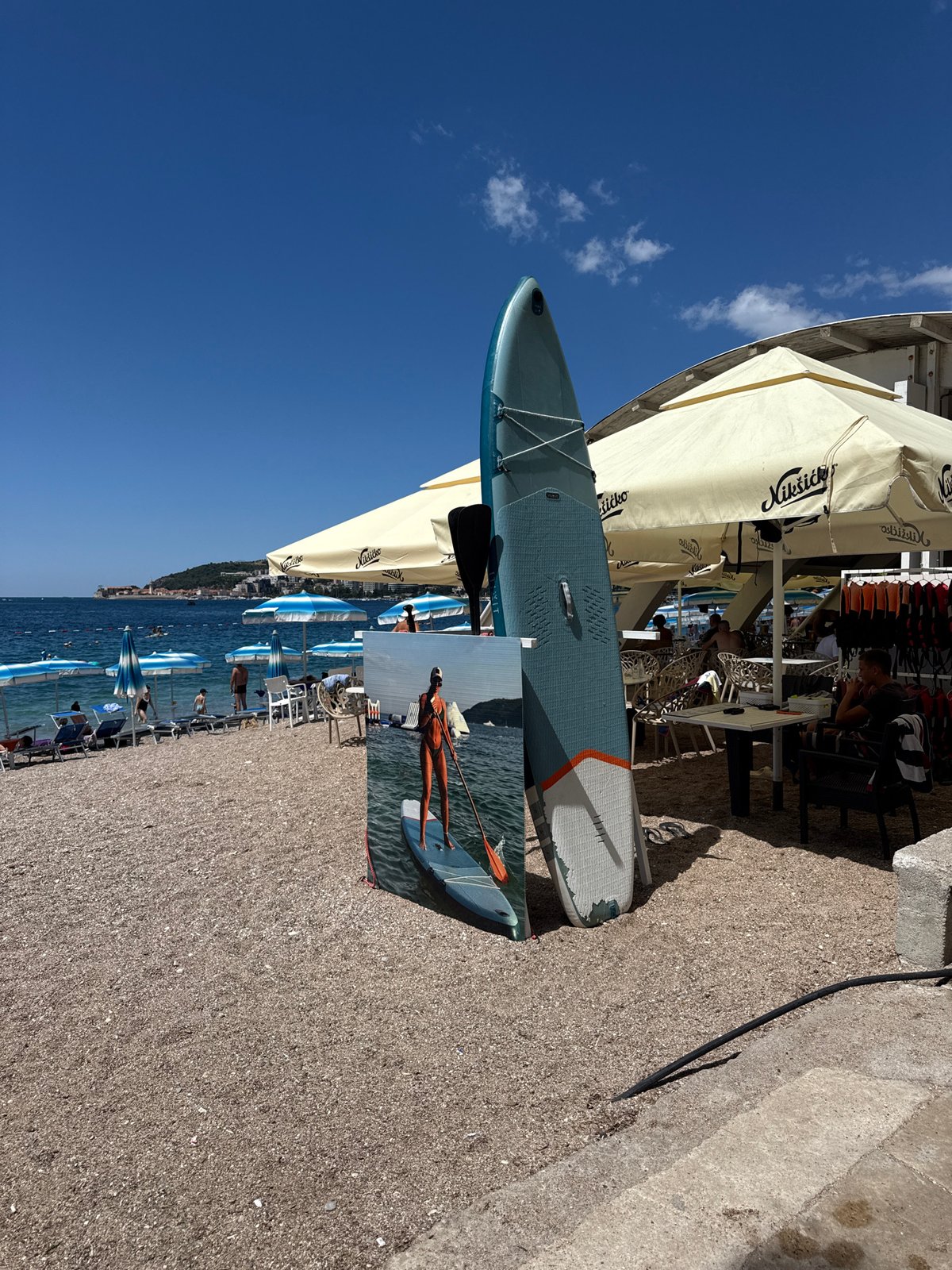 Sunny day on the beach in Budva, paddleboard ready to go.