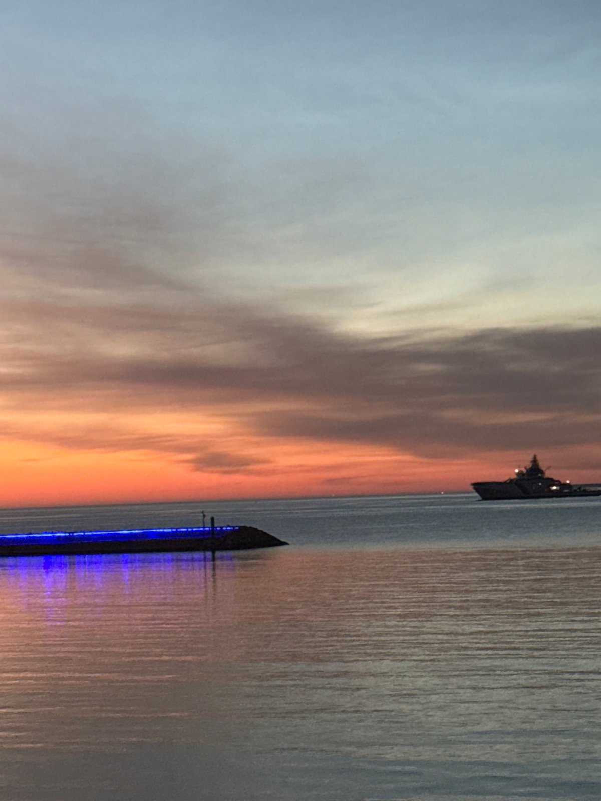 Twilight documented along Tallinn waterfront with warship presence