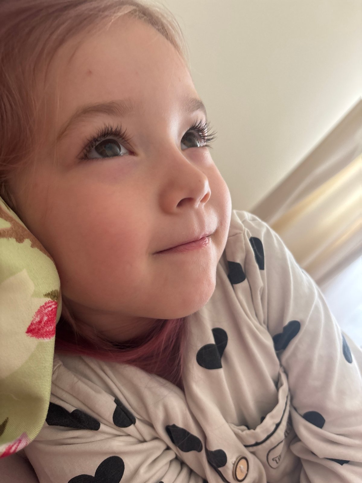 Quiet morning rest, heart-print pajamas and a strawberry pillow