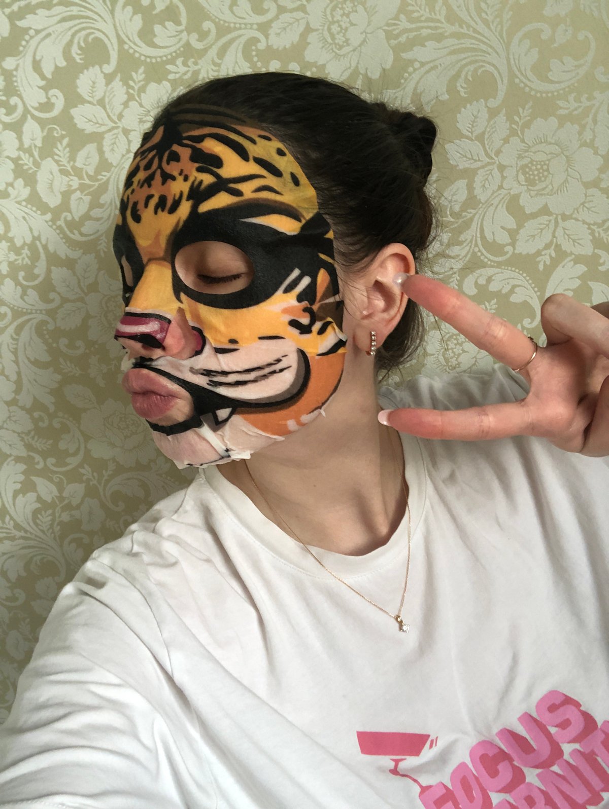 Person enjoys tiger-print face mask during skincare routine in Russia