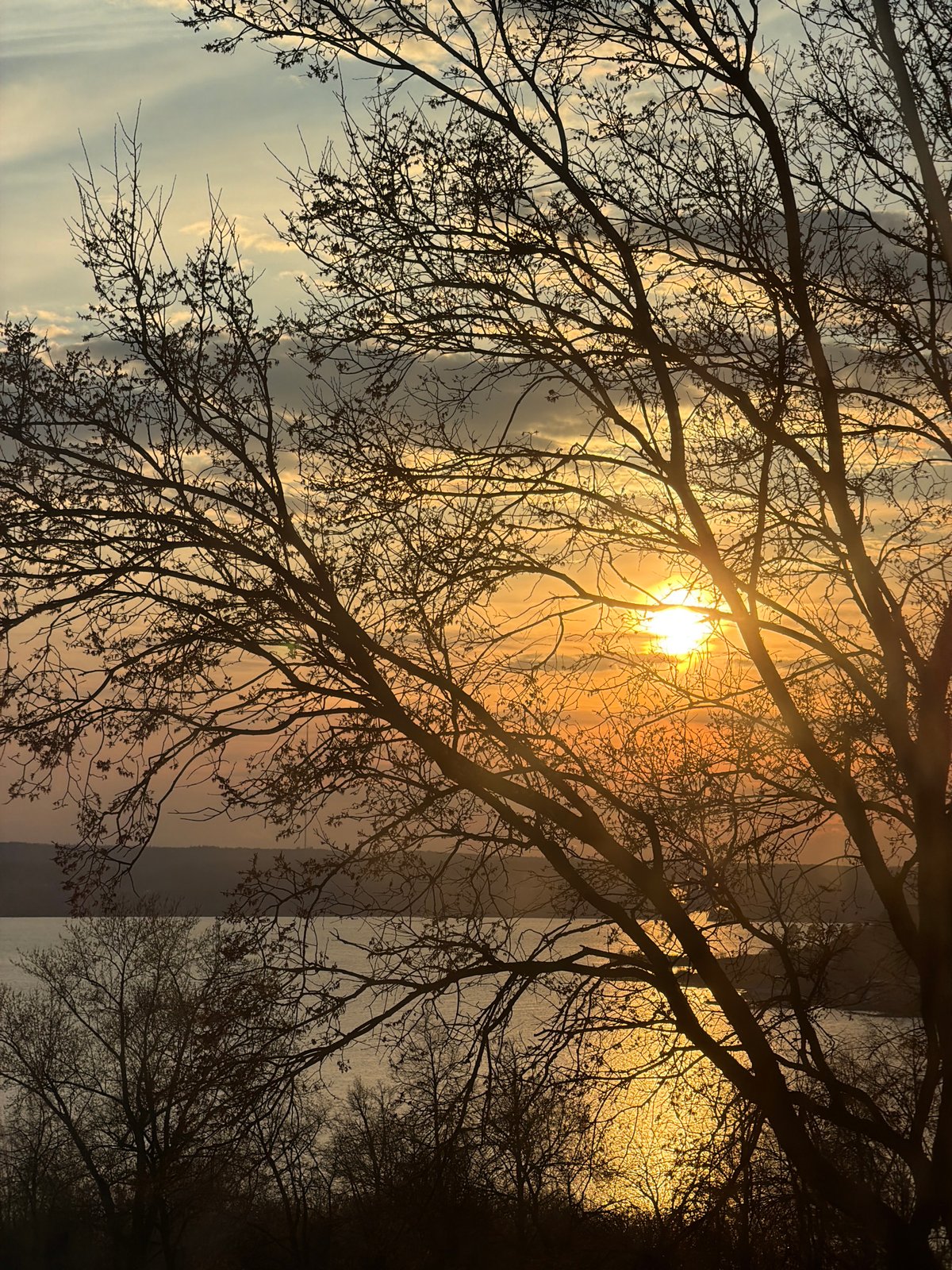 Dramatic sunset captured over Izhevsk Pond with silhouetted trees