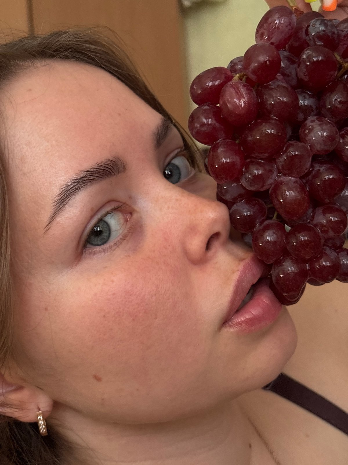 Person photographed with red grapes in Izhevsk, Russia
