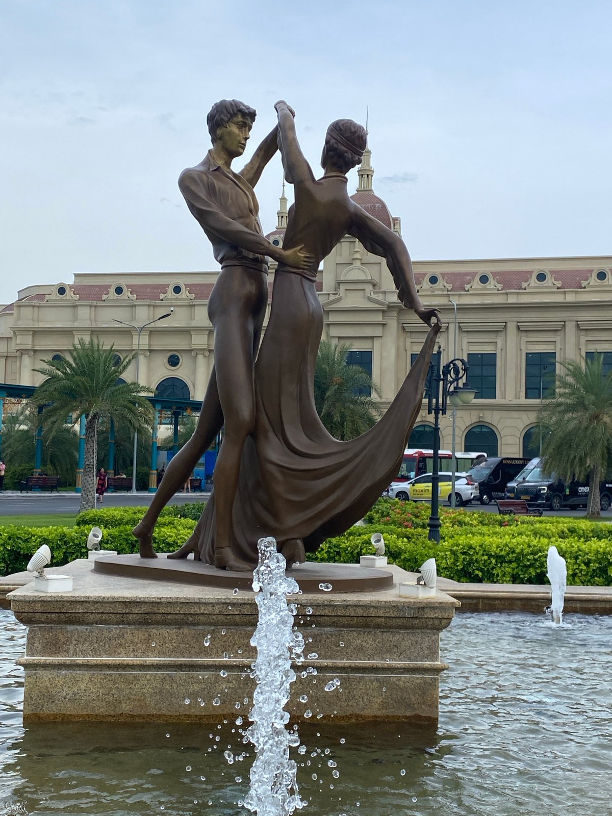 Nha Trang resort complex with fountain, wet flowers, and classical architecture