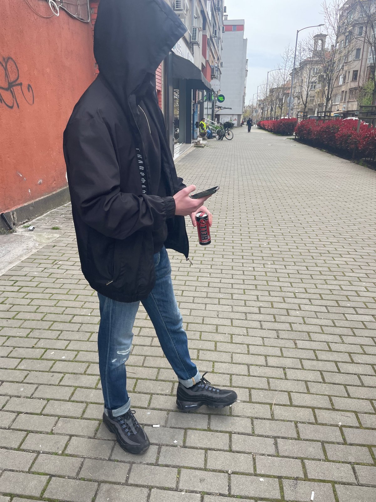 Person walks Burgas streets, enjoys energy drink indoors