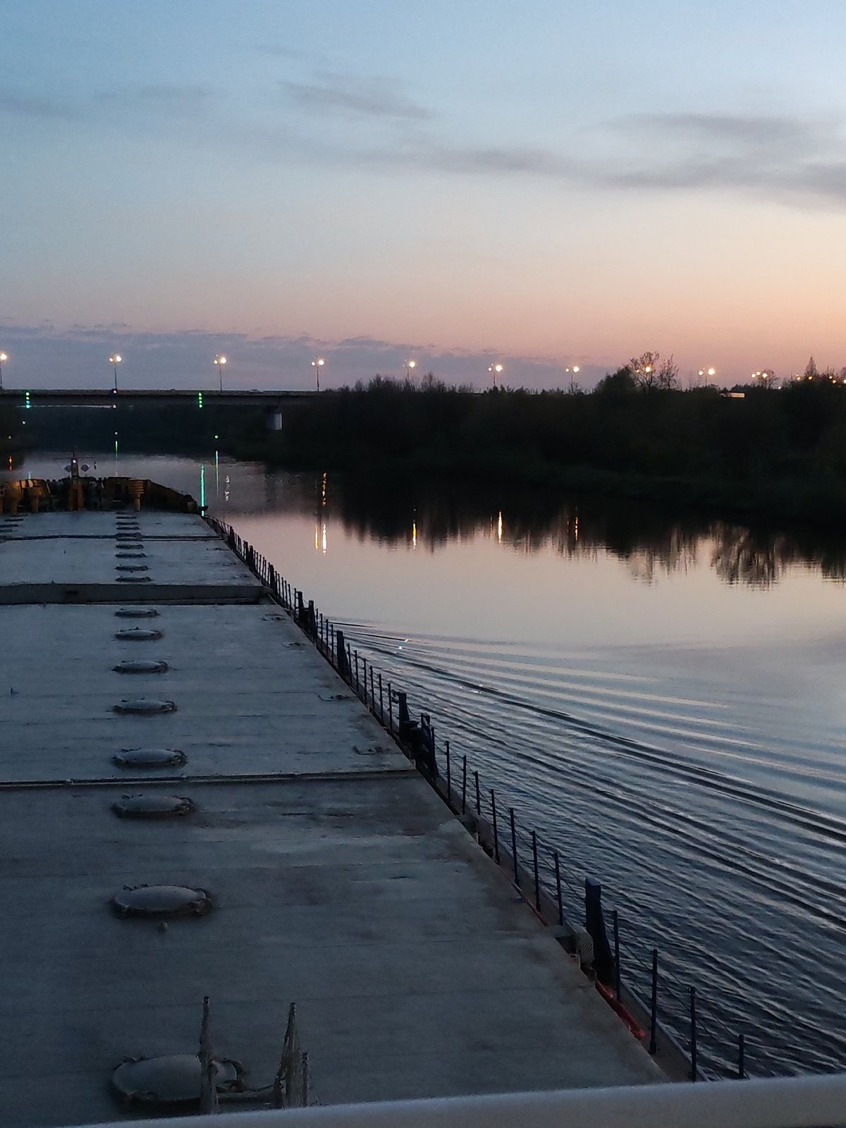 Barge navigates Dmitrov waterway at twilight