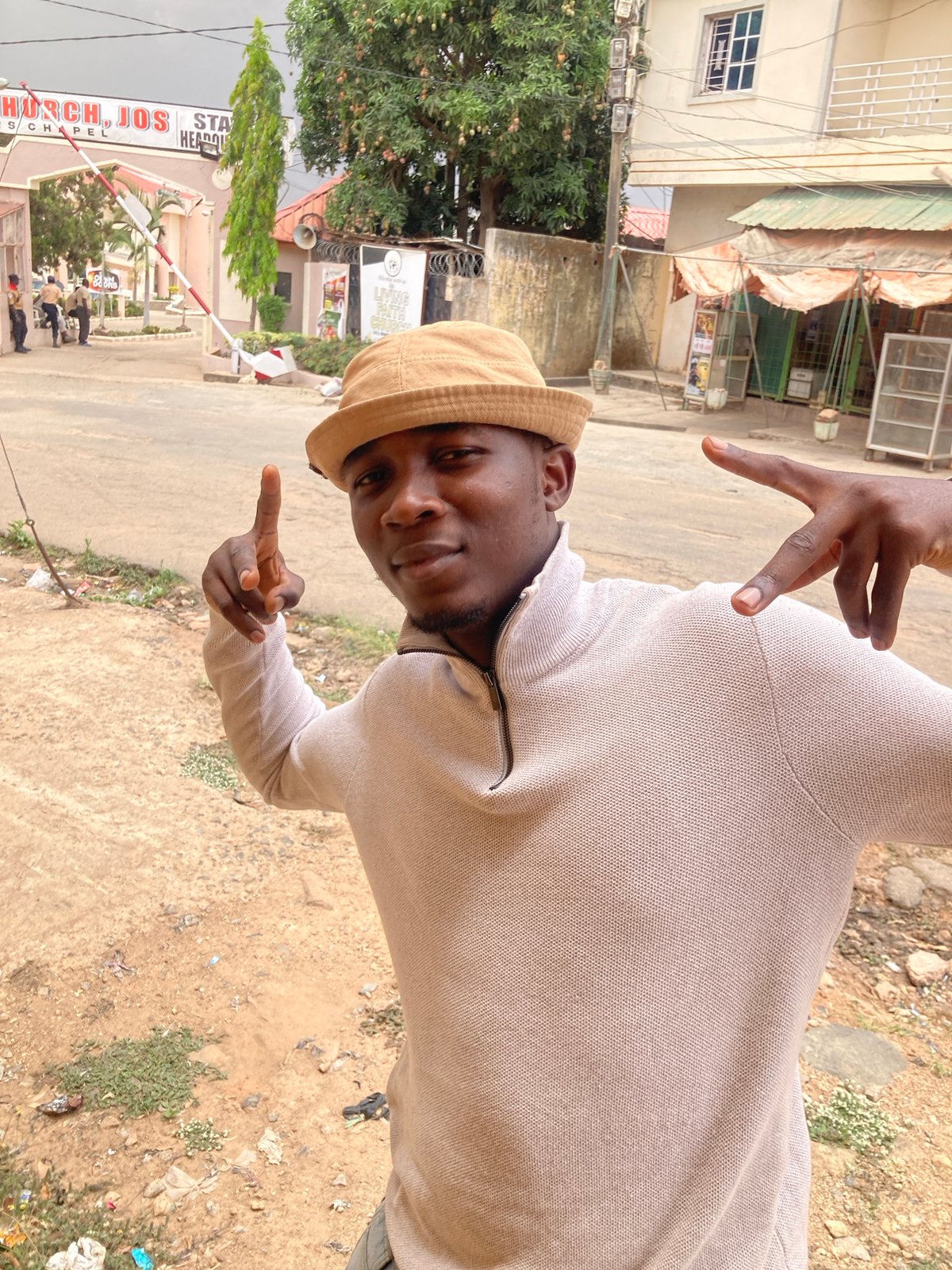 Young man poses, dances on Jos street in playful photo session