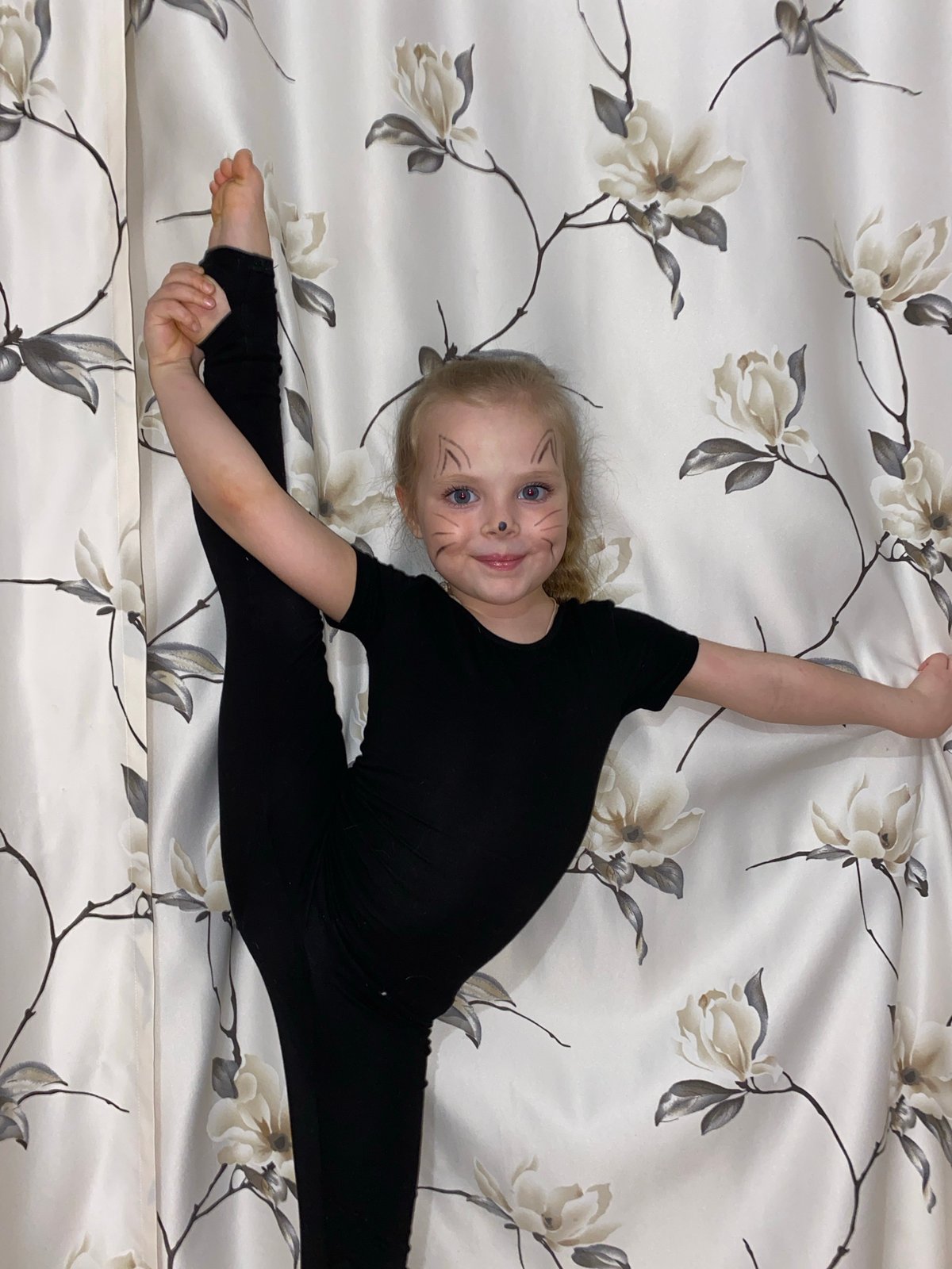 Young gymnast with cat face paint performs splits in Votkinsk
