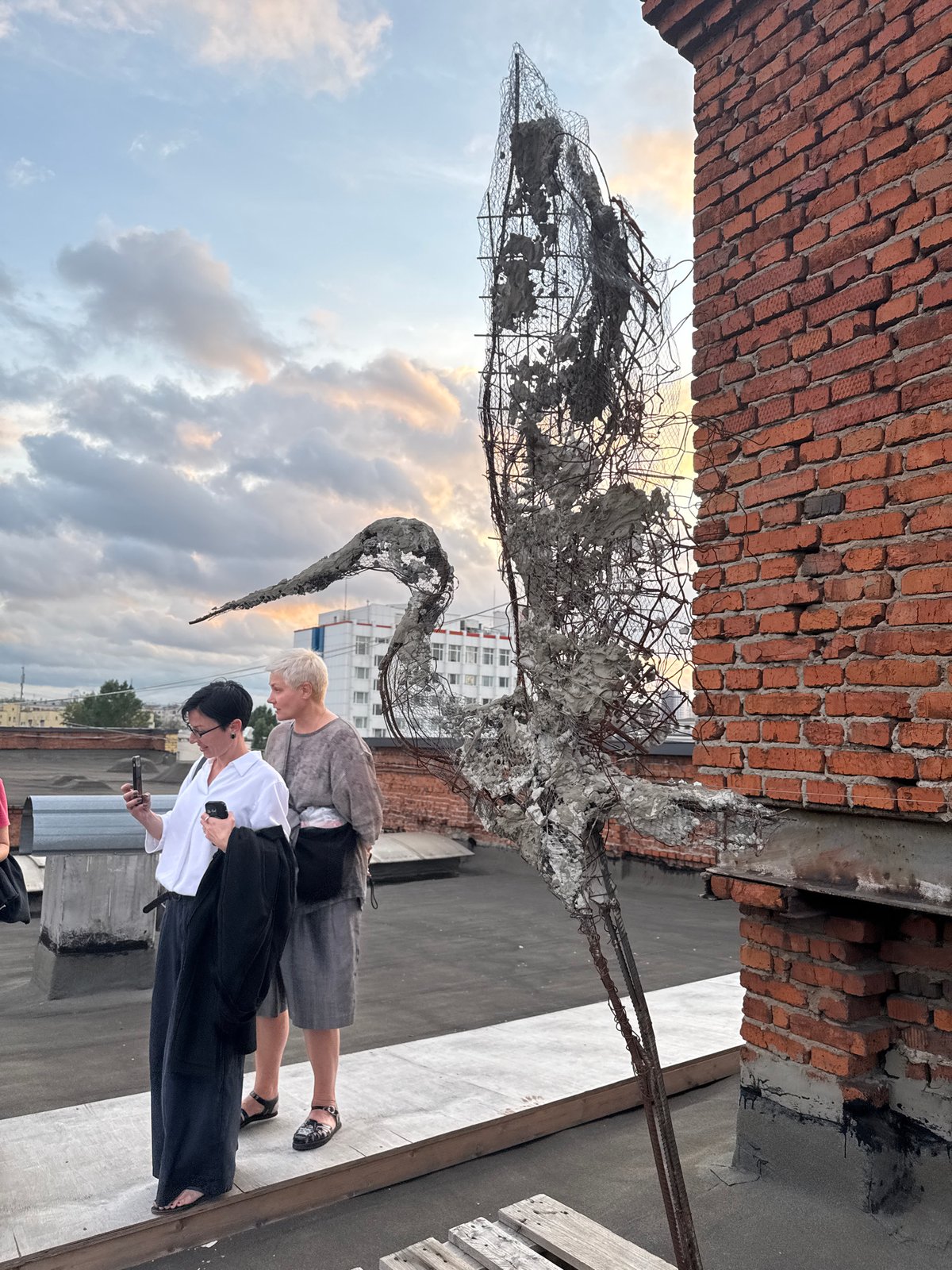 Rooftop art event at a Moscow industrial venue, stormy sunset