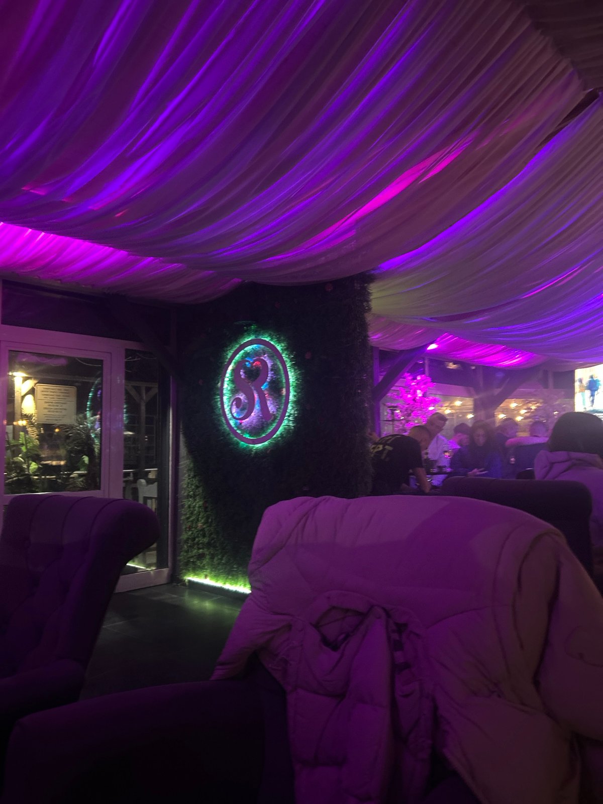 Nightclub interior captured in Zlatograd with purple lighting, draped decor