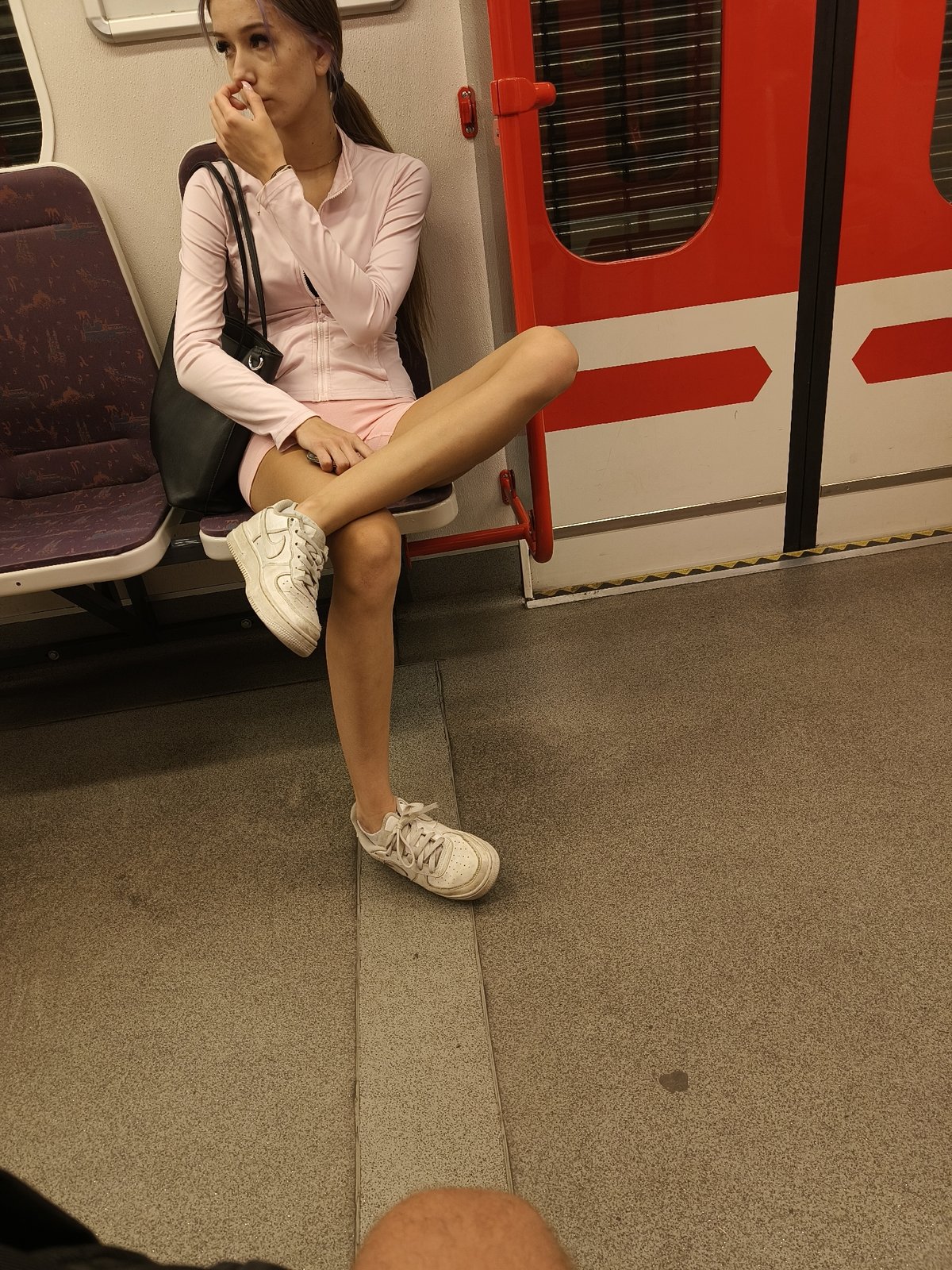 Quiet moment aboard the Prague Metro, pink tracksuit, mid-ride