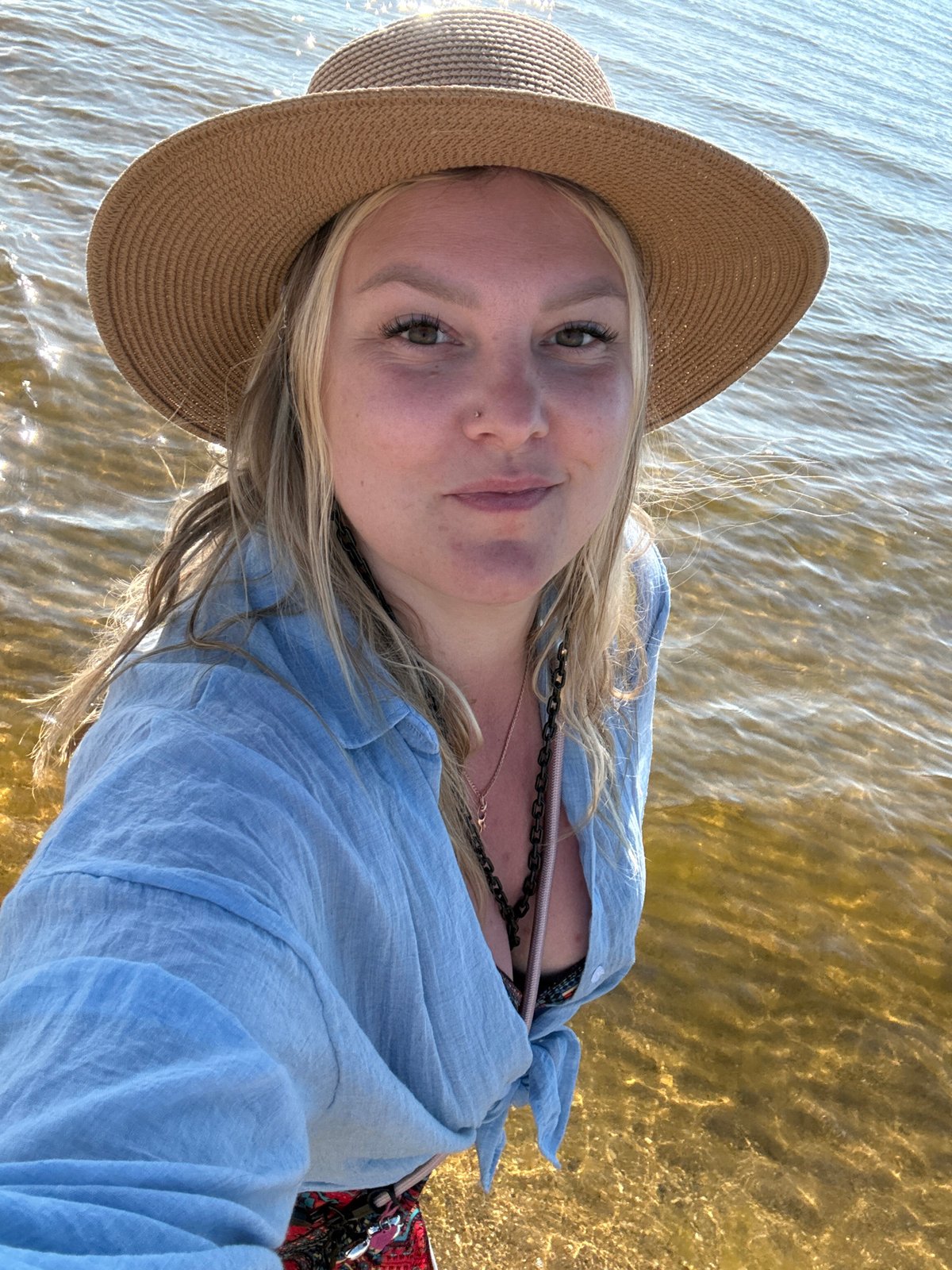 Woman takes beach selfies in shallow water in Anapa