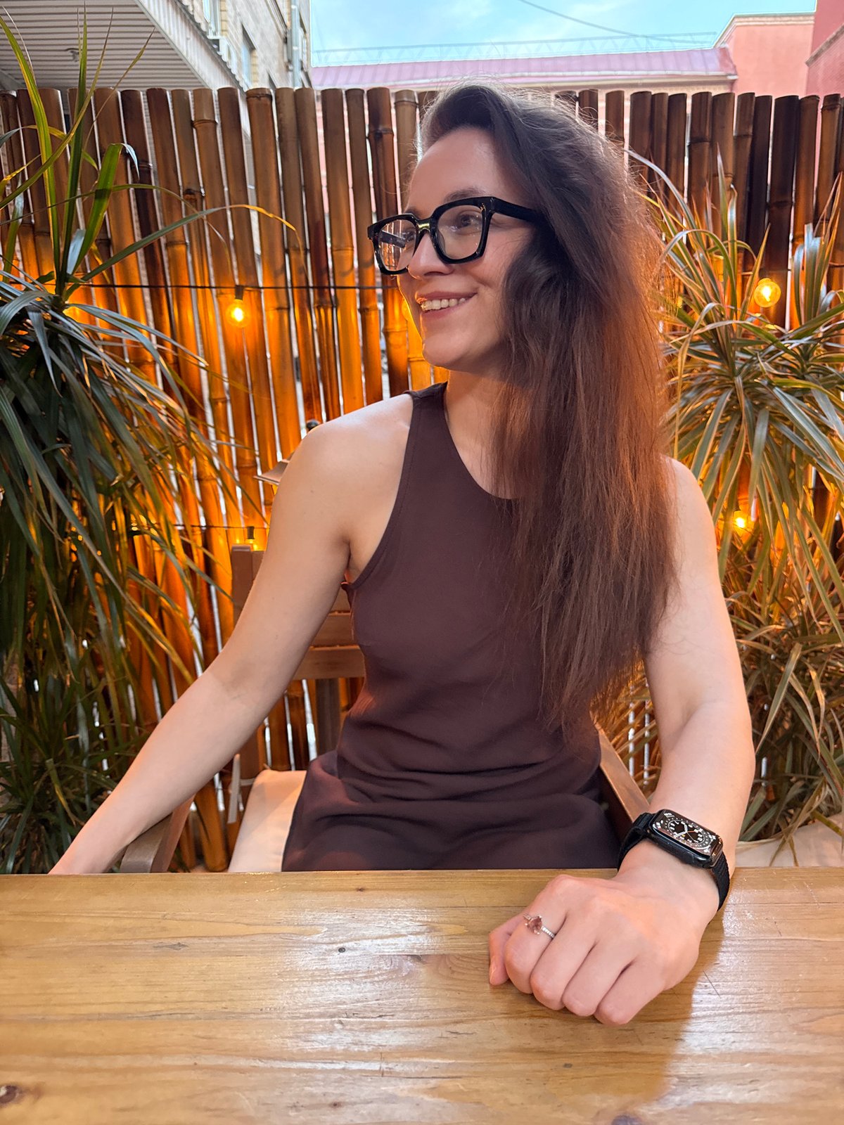 Woman sits at wooden table in bamboo-decorated Moscow venue