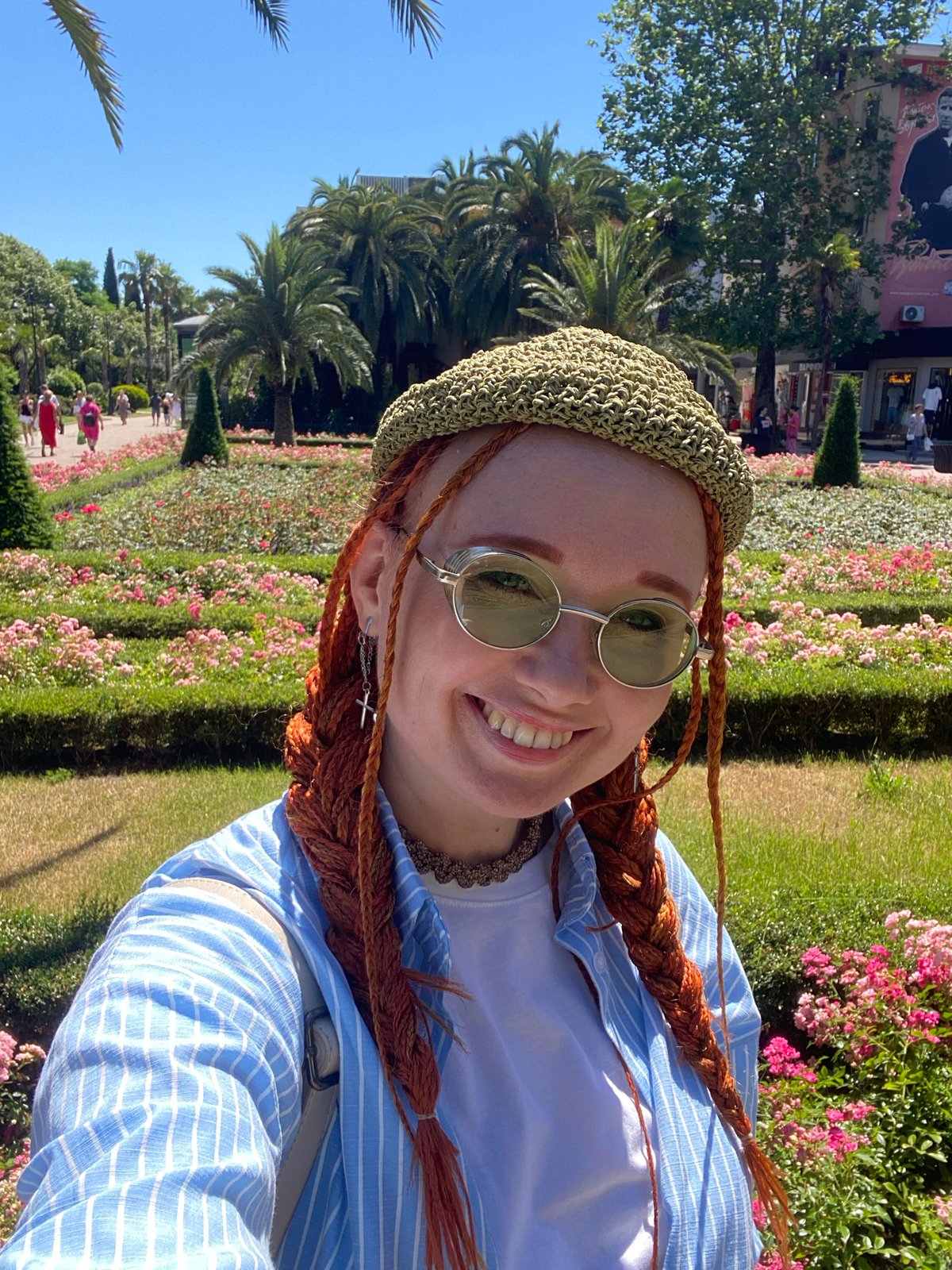 Sochi city park on a bright summer morning, roses and palms