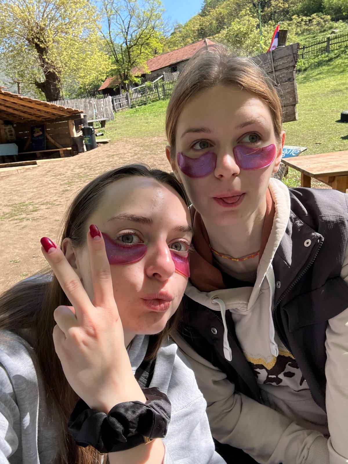 Two women pose for selfie with purple patches in Serbia