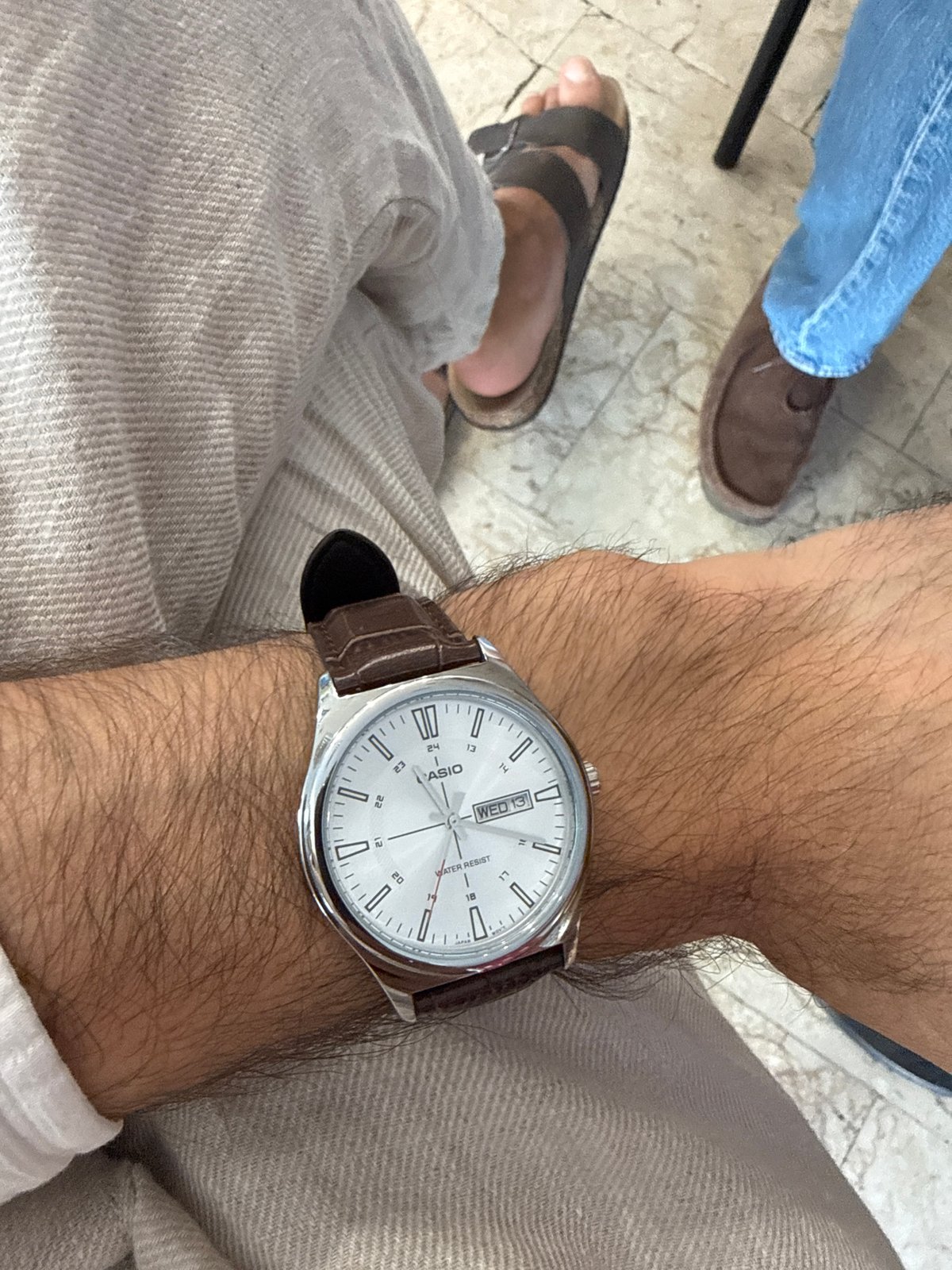 Milan office wrist check: silver watch, leather strap, hourglass desk