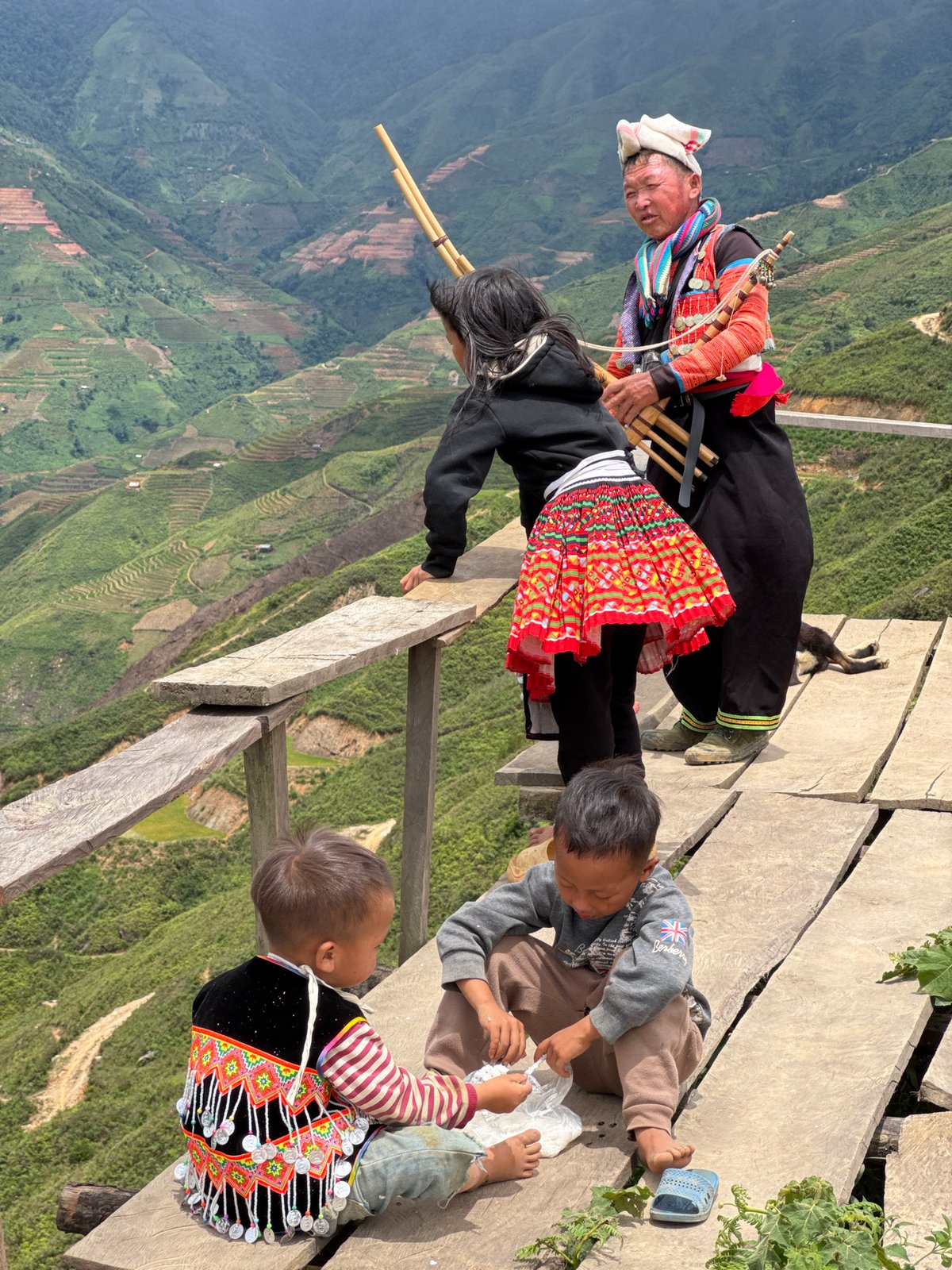 Tourists gather at Ta Xua scenic overlooks with Vietnamese flags