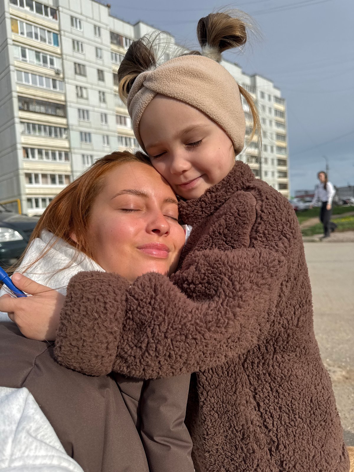 Woman, child walk dog through Chaikovsky on quiet morning