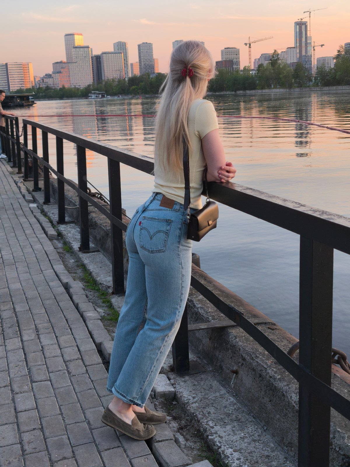 Woman enjoys sunset view from Moscow's Frunzenskaya Embankment