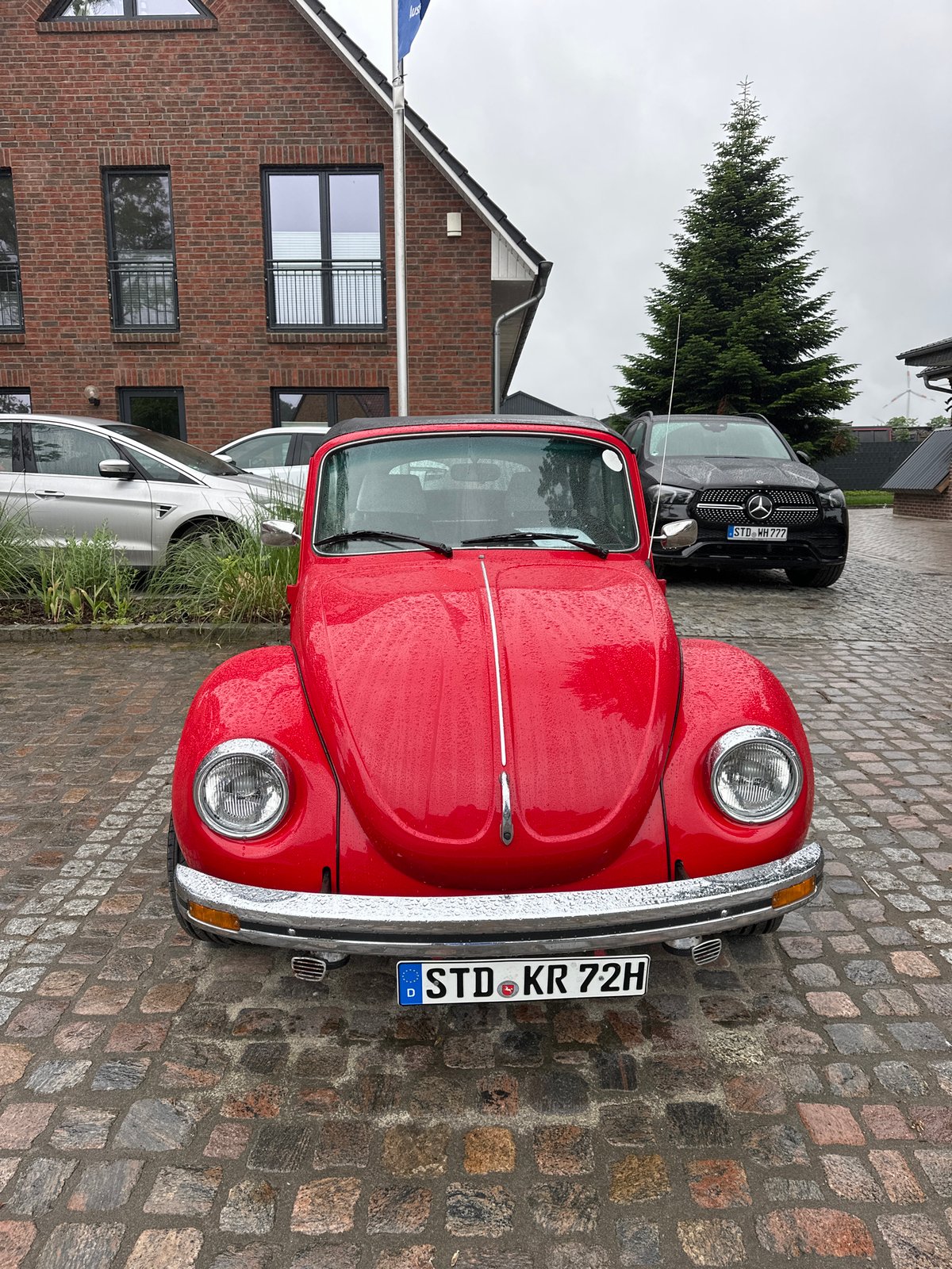 Rainy morning gathering documented in Deinste, Germany features classic cars