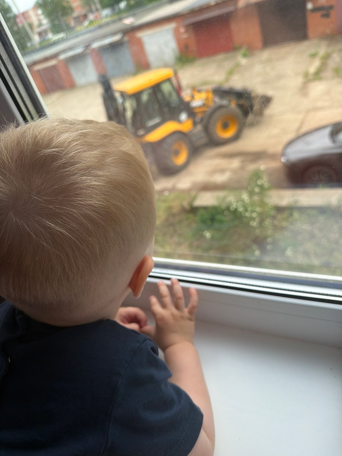 Blonde toddler gazes out window in Votkinsk, Russia